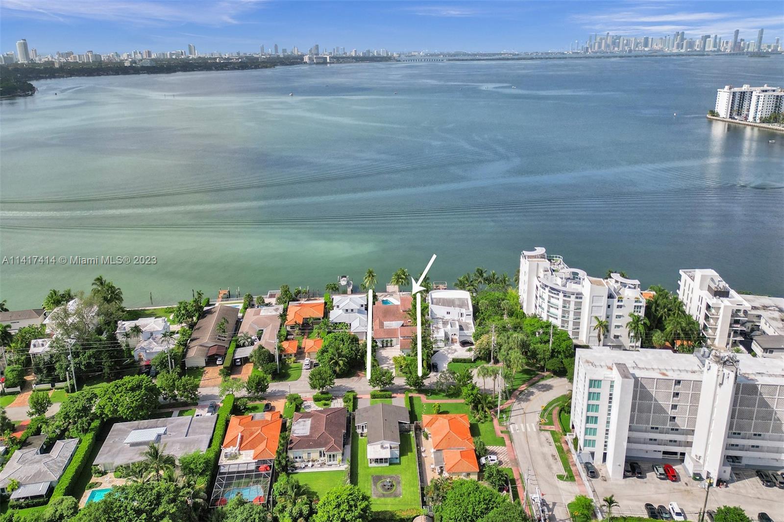 This flawlessly redone upscale waterfront home boasts unmatched, unobstructed panoramic views of Biscayne Bay and downtown Miami. The stunning interior showcases elegant carrara marble flooring throughout, the chef's kitchen with Viking appliances has been newly renovated. Upon entering through the front iron gate, you'll immediately be greeted by water and a private courtyard leading to the two-story main residence and a guest apartment above the two-car garage. The home is equipped with impact windows and doors. The formal dining room provides a picturesque view of the Lanai fountain while the living room features cathedral ceilings, creating a grand welcoming ambiance. The 62 FT long seawall has been raised, and the waterfront dock allows for easy ocean access without any fixed bridges.