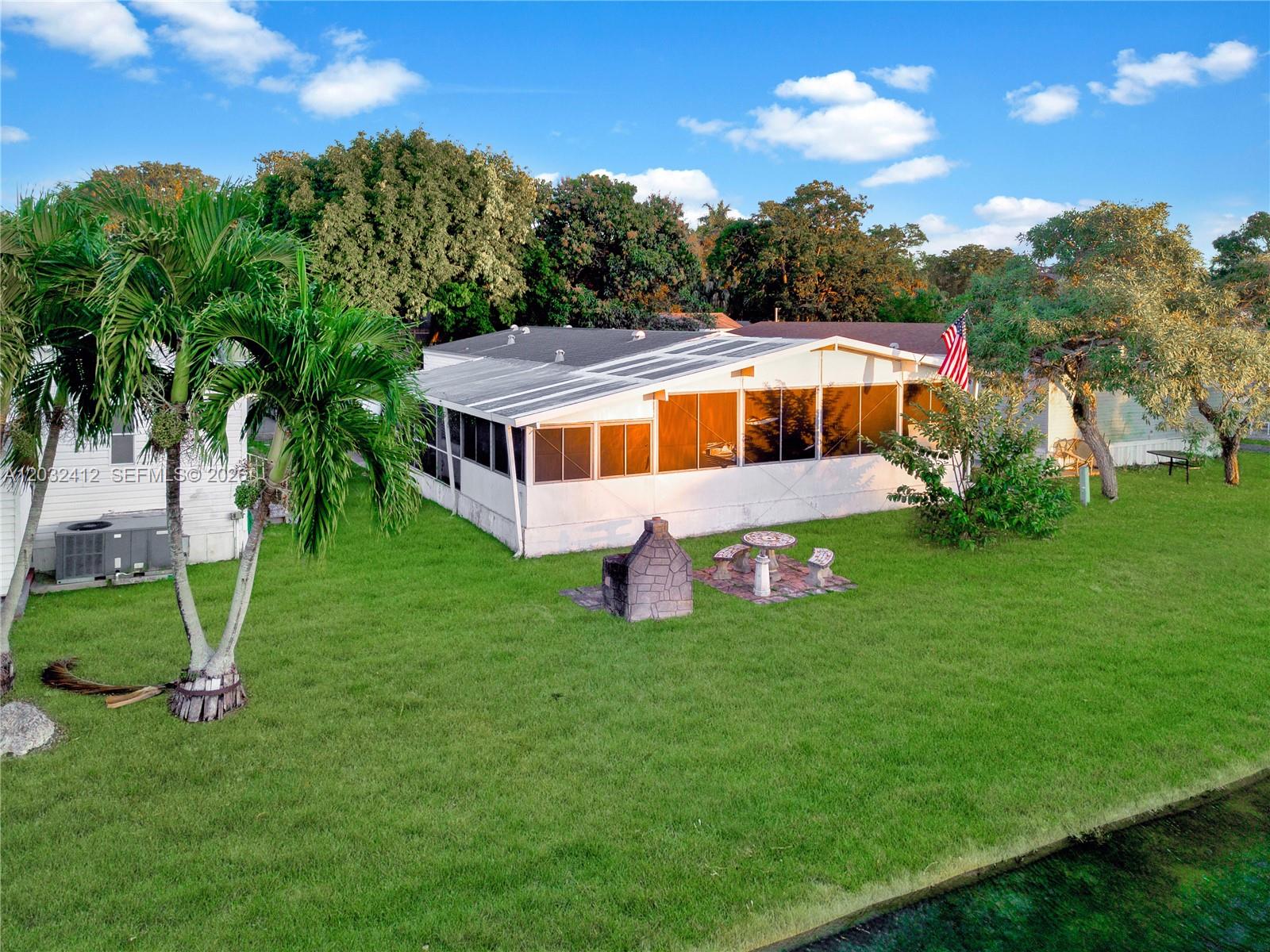 Experience waterfront living in this spacious home located in the established, gated community of Gateway Estates. Offering a rare direct lakefront position, this property provides a peaceful backdrop and serene water views right from your backyard. Step past the shade of a magnificent ficus tree, through the charming screened front porch, and into a bright, open kitchen and living area. The home offers ultimate versatility, with a legally converted porch that serves as a third bedroom, home office, or extra living space. Enjoy total peace of mind with major mechanical upgrades, including a brand-new 3.5-ton AC system and a brand-new, professionally installed by FPL exterior power meter built to last for years to come. The backyard is perfect for relaxation, featuring a built-in brick charcoal grill and a cozy seating area. Residents enjoy premium community amenities, including a clubhouse, pool, playground, and on-site boat/RV storage for a yearly fee. Strategically located for commuters and adventurers alike, you are close to the Florida Turnpike, Biscayne Bay, the Everglades, and the Florida Keys. This is a double-wide manufactured home eligible for financing. HOA Documents and Rules & Regulations can be found on the HOA website https://gatewayestates.org/home