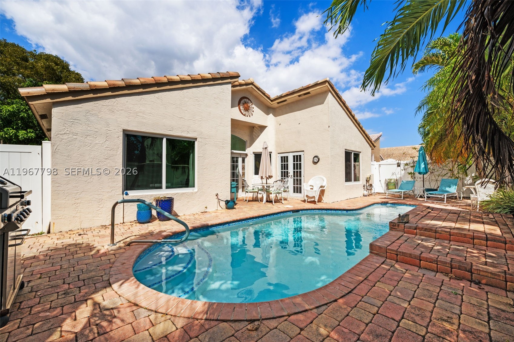 Welcome to paradise, tucked away right in the center of the highly desirable city of Deerfield Beach! This meticulously maintained home offers ultimate peace of mind with major updates already checked off your list: a new roof (2021) with a 10-year transferable warranty, new impact doors and windows (2022), a crisp A/C system (2019), built in coffee maker in the refrigerator, and a whole-house water purifier. Step out into your private, fully fenced backyard oasis to find a stunning saltwater pool (resurfaced 2021) complete with a sun shelf and a soothing water feature—perfect for relaxing or entertaining in complete privacy.

This is a private, boutique community of just 183 homes beautifully nestled in a park-like setting on the western edge of Deerfield Beach. Residents enjoy resort-style amenities, including a clubhouse, a community pool, and a tennis court. Superbly located for effortless commuting, you are minutes from the beach, Tri-Rail, the Florida Turnpike, and I-95, with easy access to Hillsboro Boulevard, Powerline Road, and Lyons Road. Don't miss this rare combination of major updates, community charm, and prime location!