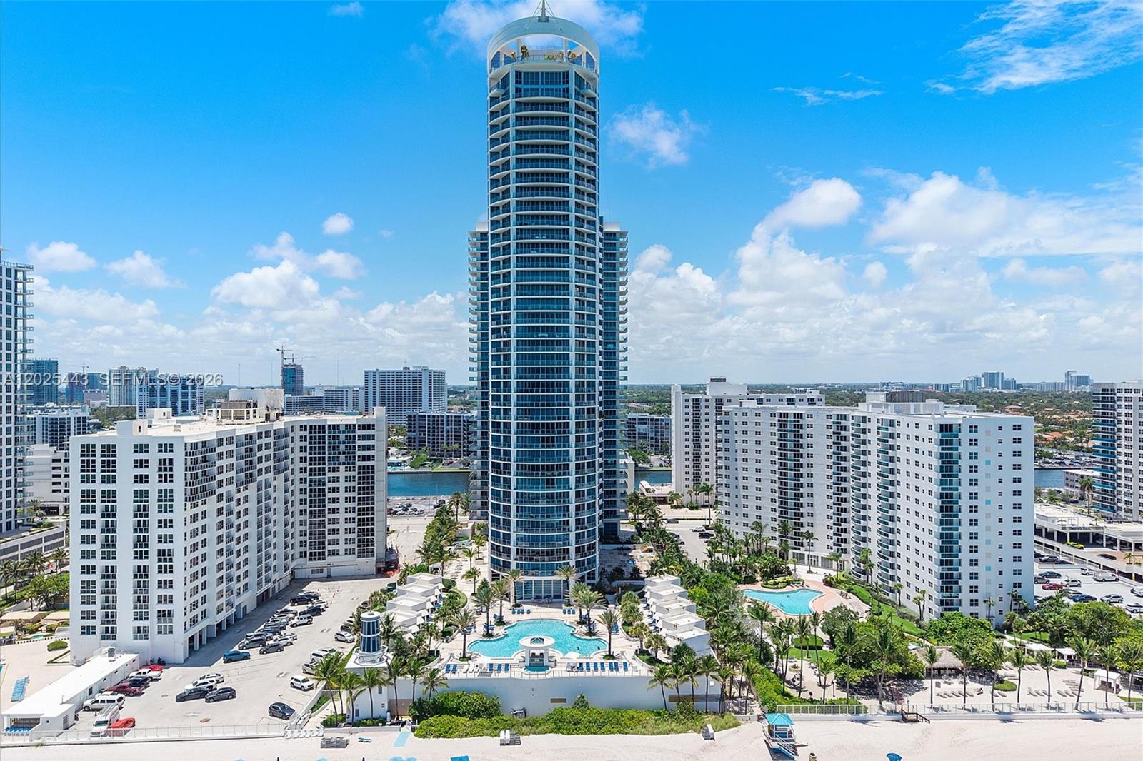 A 27th-floor oceanfront residence at Ocean Palms — three bedrooms, three-and-a-half baths, and direct, panoramic Atlantic views through floor-to-ceiling impact glass. Private elevator entry into 2,627 sq ft of air-conditioned living, plus a 456 sq ft terrace for sunrise over the ocean (3,083 total sq ft). The Aegean flow-through plan: great room running the full width of the residence, primary suite 19'2 x 19'6 with walk-in closet and spa-style bath, two ensuite secondary bedrooms, dedicated laundry, powder room off the foyer, marble floors throughout.

Ocean Palms is a 262-unit full-service oceanfront tower (2005): infinity-edge pool, direct beach access with towels and chairs, 24-hour concierge and valet, ocean-view fitness center, tennis, private theater, billiard room, beachside BBQ. Two minutes to Hollywood Beach Boardwalk, twenty to Fort Lauderdale-Hollywood International, thirty to Miami.