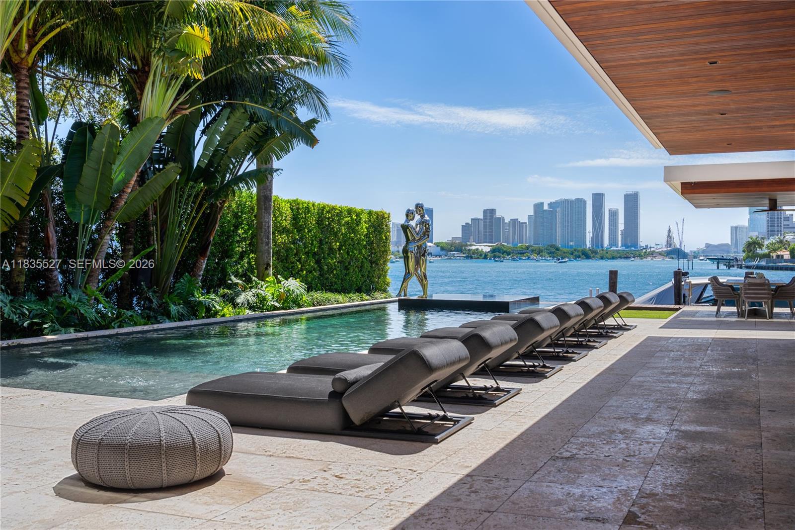 RARE VENETIAN ISLANDS TROPICAL MODERN WATERFRONT ESTATE WITH DIRECT DOWNTOWN MIAMI CITY SKYLINE VISTAS OVER THE BAY ON THE COVETED SOUTH-SIDE OF SAN MARINO ISLAND! Stunning Bayfront Residence Perched on OVERSIZED 15,750SF LOT & A HALF with 90FT of Waterfrontage. Multi-Vessel IPE Dock w/Lift & Jet Ski platforms. 5 Large Suites each with Ensuite Baths + 2 Powder Rooms + Office + Family Room. Theater w/Surround Sound & Lounging Beds. Open modern floor plan, wrapped by 10 FT Telescopic Fleetwood Glass Doors, provides Seamless Indoor/Outdoor Living. Blonde Oak Floors & Gourmet Eat-in Kitchen with Gas Range & Stainless Steel Miele Appliances sits adjacent to Catering Kitchen with Pantry & Separate Service Entrance. Comfortable Breakfast Area, Wine Room & Bar. Spacious Primary Suite draped by Panoramic Sunsets over Miami Skyline with two dressing rooms + Bookmatched Marble Bath with Rain Shower & Deep Soaking Tub. Wraparound Terraces in Keystone with Stairs lead to an Expansive Rooftop Entertaining Area—Ample Green Space with Architectural Dark Bottom Negative-edge Pool & Spa. Modern Gazebo includes a Chef’s Summer Kitchen + Cabana Bath. Privacy Gate + 2 Car Garage.