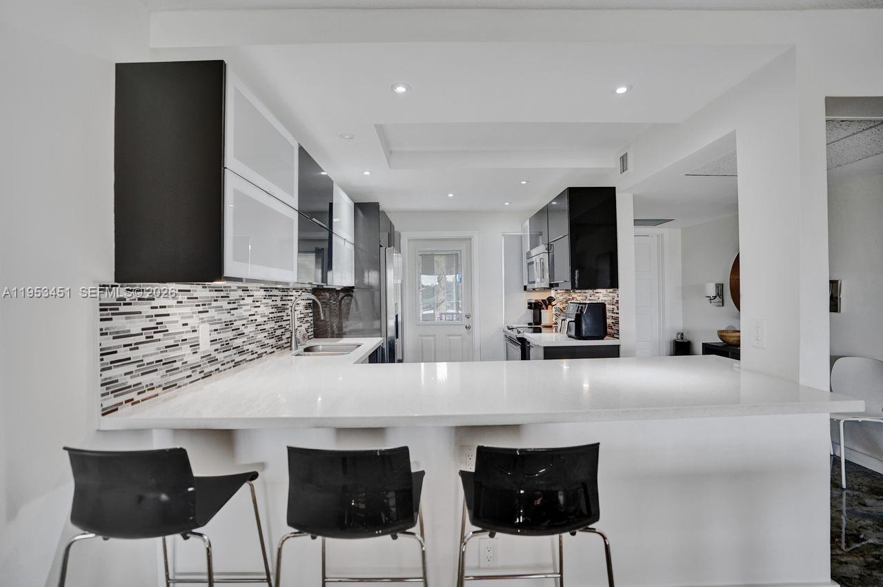 Approximately 1,100 square feet of well-designed living space in the desirable PALM AIRE condominium community. This two-bedroom, two-bathroom home features a spacious layout with abundant countertop space, sleek appliances, and modern finishes throughout. The open concept design and large windows allow for an abundance of natural light, creating a bright and airy atmosphere. 

The primary bedroom is well-proportioned with ample space for a sitting area or home office. The en-suite bathroom offers a spacious shower, modern vanity with abundant storage, and tiled walls for a luxurious feel. The second bedroom is also generously sized, providing flexibility for a guest room or home gym.

The home's open floor plan seamlessly transitions to a scenic patio with a golf course view, offering a peaceful outdoor oasis. The condominium has been totally renovated, featuring luxury tile flooring and quality renovation materials. You will have peace of mind with a great experienced management company and a balanced reserve budget. This assessment-free condominium building has been fully refurbished as of January 2026, including impact-resistant windows for enhanced safety and energy efficiency.
This property presents an ideal living situation for those seeking a modern, low-maintenance lifestyle with access to scenic natural surroundings.