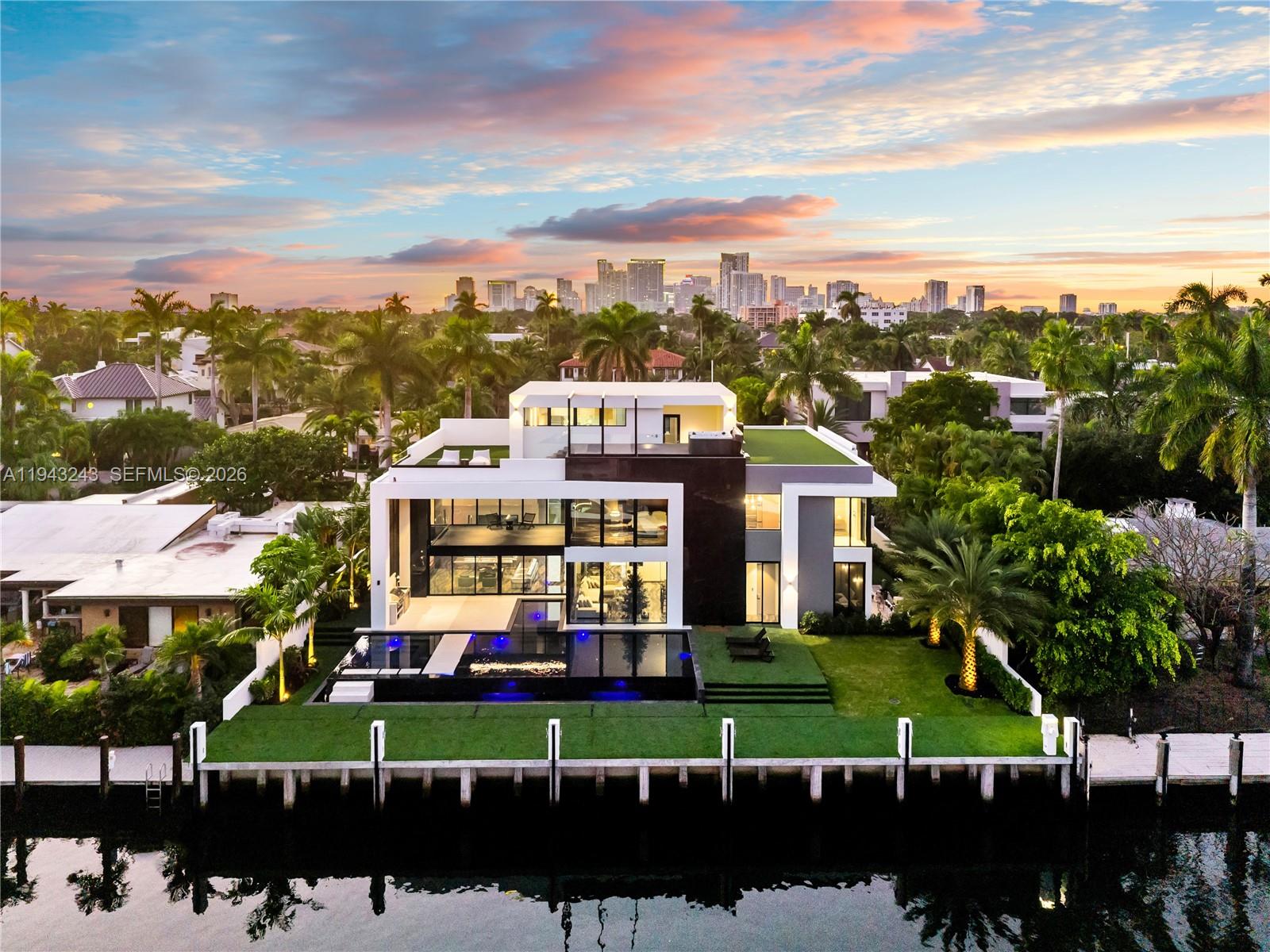 An extraordinary expression of contemporary luxury, this newly constructed Las Olas Isles estate is a rare convergence of design, craftsmanship, and waterfront prestige. The three-story residence features 100 feet of deep-water frontage, bespoke European craftsmanship, five bedrooms, and a one-of-a-kind expansive home office.

Over $1.4M in Italian millwork by renowned Italian manufacturer Febal Casa defines the interiors, where nearly every surface is finished in custom upholstered wall panels. Immaculate architectural detailing creates a richly layered, refined, and acoustically elegant environment; with the exception of the ceilings, less than 1% of the home utilizes drywall—an extraordinary level of finish rarely seen.

Offered fully furnished and turnkey, the home showcases a globally curated collection of custom and designer furnishings, many created exclusively for this residence. Book-matched porcelain flooring imported from Spain flows throughout, complementing the chef’s kitchen outfitted with Miele appliances and integrated Italian sinks. Lutron home automation, Delta lighting inside and out, Grohe and Kohler fixtures, and a custom-furnished elevator deliver seamless, elevated living.

Additional highlights include a full private theater with custom paneling, floor-to-ceiling doors with concealed hinges, a rooftop jacuzzi and entertainment area, and a brand-new concrete seawall and dock—ideal for yachting, designed and built by Prince Bay Luxury Group