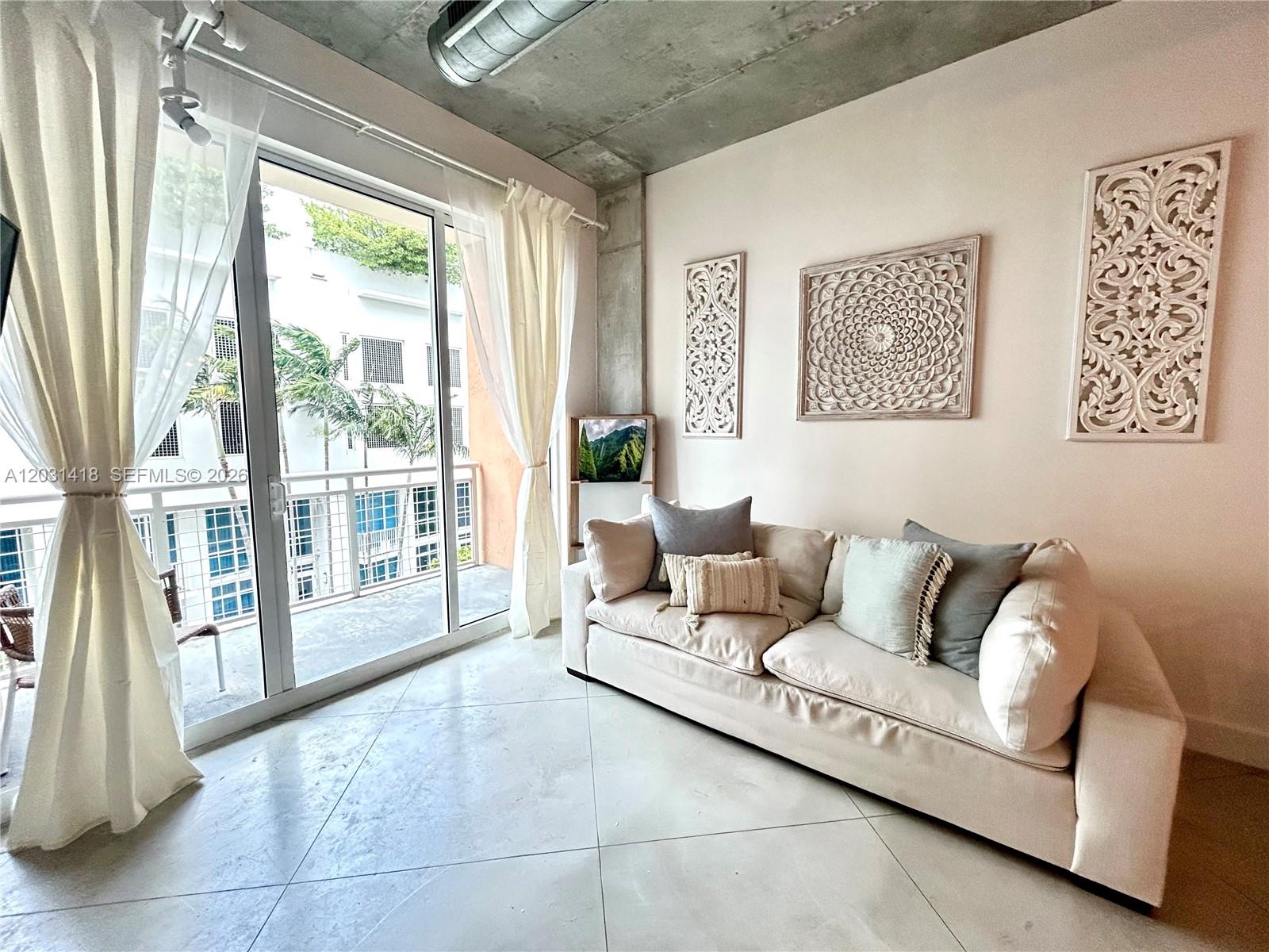 Bright and spacious condo features oversized impact windows and sliding glass doors that fill the home with natural light. Polished concrete floors, soaring ceilings, exposed industrial piping, and concrete columns create a unique urban loft aesthetic, while still feeling warm and comfortable.

Apartment can be purchased fully furnished with décor and kitchen ware. Apartment can be leased monthly (30 day) or yearly.

The spacious bedroom includes large impact windows, a walk-in closet with custom built-in shelving, and plenty of storage throughout. Additional storage features include a hall closet and a dedicated laundry closet with washer, dryer, and built-in shelving. The oversized bathroom offers a 72-inch stone-top vanity with generous drawer storage. The kitchen is fully equipped with a refrigerator, ice maker, self-cleaning oven, microwave, dishwasher, and garbage disposal. New appliances purchased in 2023. Enjoy your private balcony with both city views and a partial bay view. Perfect for morning coffee or evening relaxation.

Residents enjoy resort-style amenities including a pool, jacuzzi, fitness center, club/game room, package lockers, valet service, EV charging stations, and a secure gated parking garage.

Conveniently located above coffee shops, bakeries, restaurants, and smoothie shops. Building is across from waterfront Margaret Pace Park, offering waterfront walking paths, outdoor fitness areas, green space, and a designated dog park.