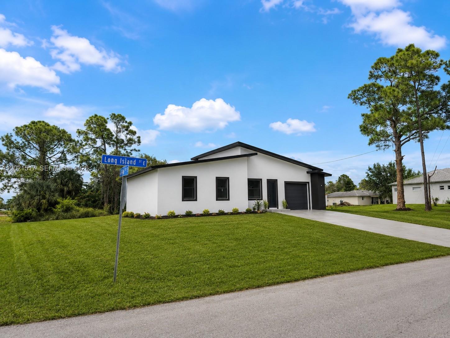 Brand-new contemporary residence in one of Lehigh Acres’ most desirable area. This stunning new construction offers 3 bedrooms and 3 bathrooms, including a conveniently located full bathroom near the garage area. Featuring soaring ceilings, oversized porcelain floors, impact windows and doors, and an open-concept layout filled with natural light. Designer kitchen with custom cabinetry, quartz countertops, large waterfall island, and spacious living areas ideal for entertaining. Elegant bathrooms with upscale finishes. Modern architectural lines and premium craftsmanship throughout. One-car garage, wide driveway, and beautiful curb appeal with fresh landscaping. Conveniently located near shopping, schools, parks, restaurants, and major roadways while still offering privacy and peaceful surroundings. A perfect opportunity for homeowners or investors seeking luxury style at an exceptional value. Move-in ready with high-end finishes throughout. Easy to show. Call listing agent.
