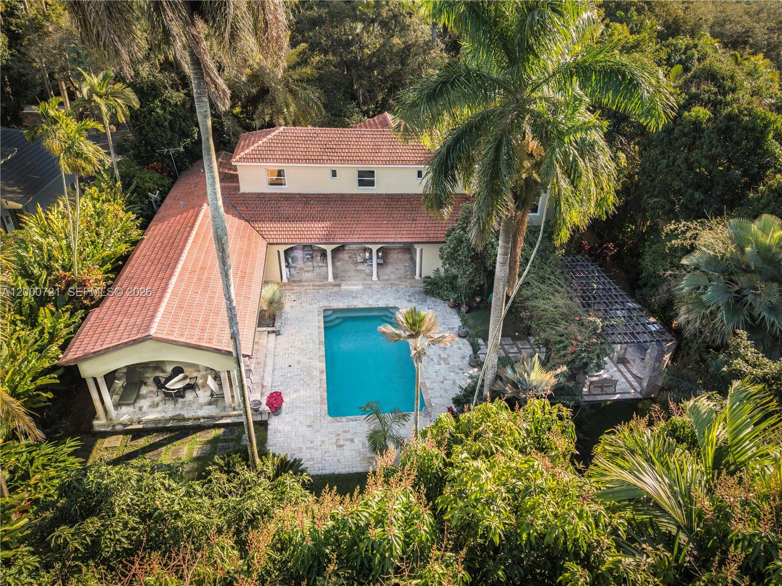 Set in coveted Ponce Davis, this exceptionally maintained estate delivers elevated comfort and peace-of-mind infrastructure. The 6 bedrooms and 6.5 baths home is anchored by it’s ground-floor primary suite complete with a coffee bar, steam room, his-and-hers closets, and a private patio retreat overlooking the salt water pool and lush backyard. The kitchen is a showpiece with top-tier appliances including Sub-Zero, Wolf, Miele, and Viking which flows seamlessly to the family room and easy access to the outdoor patio & summer kitchen. Added peace of mind from the generator supported by 1,000-gallon propane tank. On the near acre property, discover a collector’s tropical garden—a rare sanctuary featuring 100+ varieties of palms and cycads. Complete with a 2-car garage andtimeless Ponce Davis appeal, this is a one-of-a-kind home.
