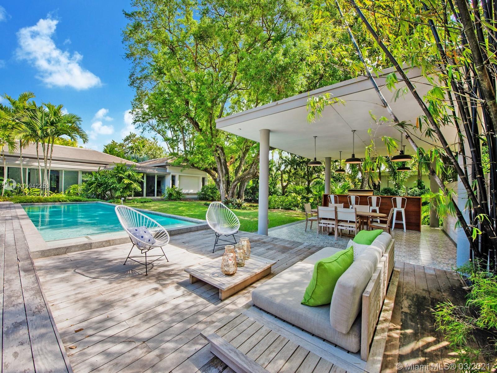 Custom Built Mid Century-Tropical Modern estate located in N Pinecrest. A tropical paradise nestled on a 34,717 sf lot enveloped by lush landscaping. Greeted by a boundless flr plan w/exquisite finishes & endless all-around views of the gorgeous backyd oasis w/huge windows & doors, providing bountiful natural light. The open flr plan offers a spacious living & dining rm w/high ceilings & integrated spaces. Custom Chef’s kit w/Thermador Appl, gas range, breakfast area & huge family rm great for entertaining family/friends. Main Bedrm offers walk-in closet, patio area, spa-like bath w/shower, floating tub & double vanities. Media rm located outside main & secondary bedrms. Add features: poured Concrete Roof, service quarters, limestone & wd flrs, resort pool, summer kit, 2 car gar. Must See!