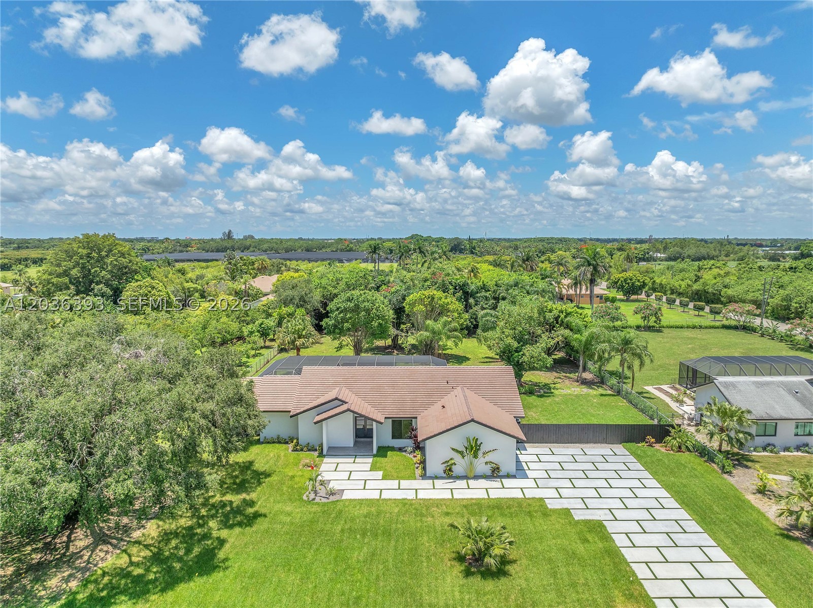 Experience refined country estate living on this spectacular 1.05-acre property, where modern luxury meets timeless elegance. This completely renovated residence offers 3,052 square feet of beautifully designed living space featuring 4 bedrooms, 2.5 bathrooms, and a spacious 2-car garage. Meticulously remodeled with no detail overlooked, the home showcases all-new plumbing and electrical systems, impact-resistant windows and doors, and a new flat tile roof, providing both exceptional quality and peace of mind. Designed for entertaining, the impressive open-concept floor plan centers around a chef-inspired gourmet kitchen featuring premium Monogram appliances, custom cabinetry, and a stunning 12-foot island that serves as the focal point of the home. Expansive living and dining areas flow effortlessly, creating an inviting atmosphere for both intimate gatherings and large-scale entertainment. Step outside to your private backyard retreat, complete with a screened 15' x 30' swimming pool and an expansive 1.05-acre homesite offering privacy, tranquility, and endless possibilities. The oversized property provides ample space for recreational vehicles, a boat, guest house, outdoor entertainment areas, or future expansion.Combining luxury finishes, modern systems, and a rare acre-plus setting, this exceptional move-in-ready estate offers a unique opportunity to enjoy the best of South Florida living.