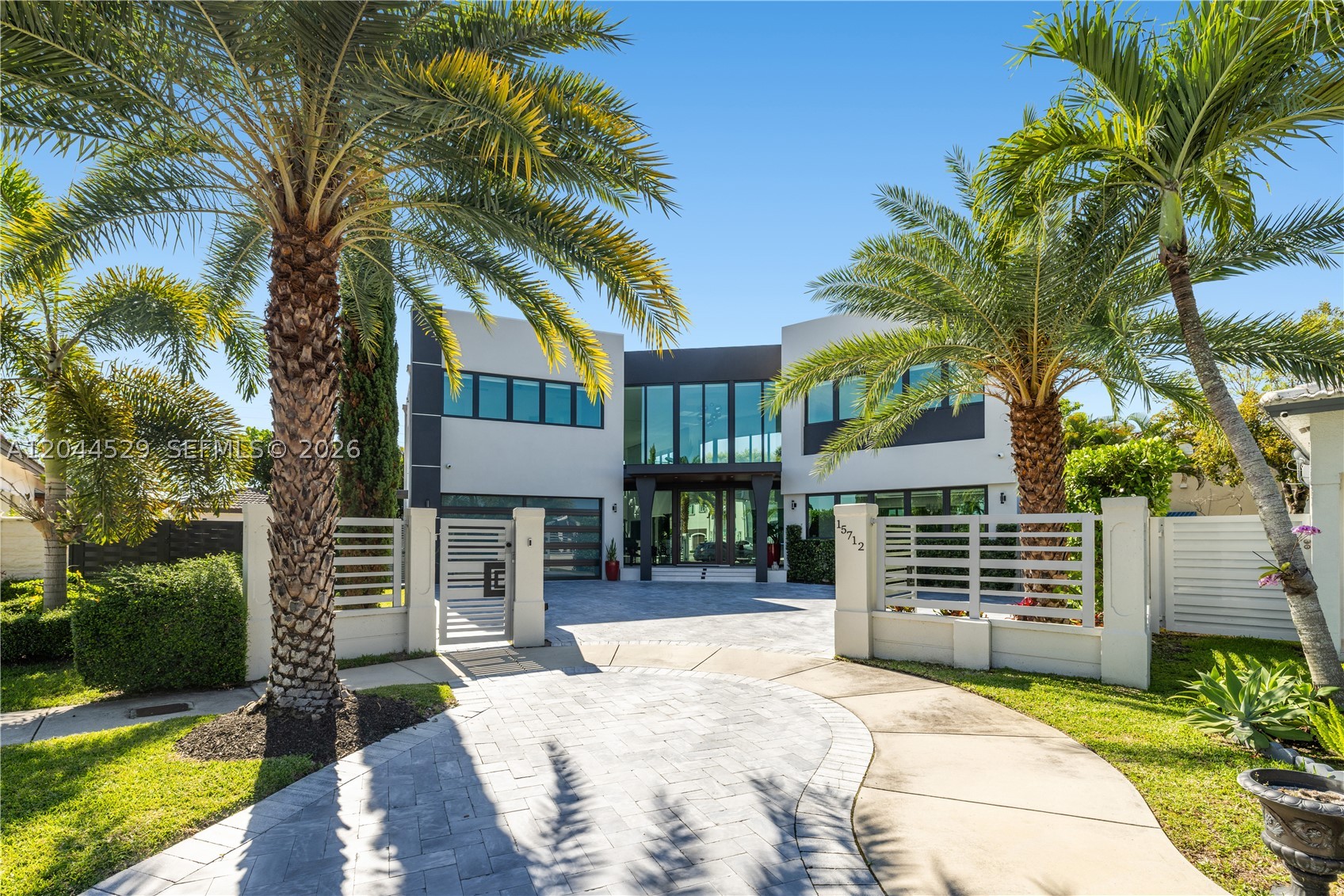 Experience modern luxury in this spectacular custom-built estate offering approximately 5,000 Sq.Ft. of exceptional living space. This architectural masterpiece features 5 spacious bedrooms, 7 designer bathrooms, soaring ceilings, and an abundance of natural light throughout. The gourmet European kitchen showcases premium finishes, an induction cooktop, and a concealed designer ventilation system. A stunning marble staircase serves as the centerpiece of the home, complemented by smart climate control and top-of-the-line finishes in every room. Enjoy seamless indoor-outdoor living with an infinity-edge pool, expansive entertainment areas, and dual access from both the front and rear entrances. A rare opportunity to own a truly one-of-a-kind residence where sophistication, technology, and timeless design come together.