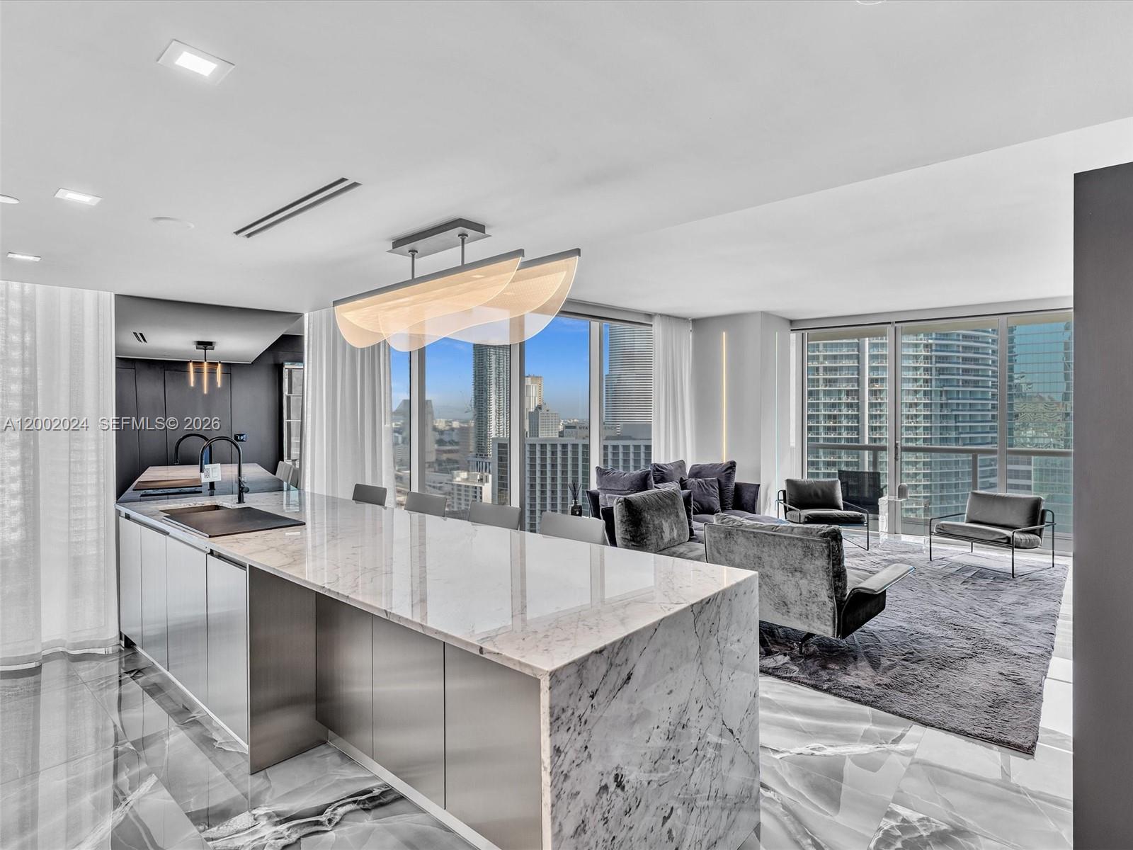 Completely reimagined designer residence at Icon Brickell offering 1,168 SF of sophisticated living with expansive floor to ceiling glass and stunning Miami River and skyline views. This turnkey home has undergone a full high end renovation and stands out as one of the most unique residences in the building. A striking oversized waterfall marble island anchors the chef’s kitchen, complemented by sleek custom cabinetry, integrated top of the line appliances, and refined modern finishes.
Designed for both comfort and entertaining, the open concept layout flows into a dramatic living space enhanced by a custom built glass enclosed bar with illuminated display, a rare feature in Brickell. Corner exposure fills the residence with natural light throughout.
The primary suite offers a refined hotel inspired retreat with a custom designer accent wall and curated lighting, complemented by a spa like bathroom featuring dual floating vanities, backlit mirrors, and an oversized walk in shower with premium slab finishes.
Step out onto a spacious private balcony and enjoy sweeping views of the Miami River and surrounding skyline. 
Thoughtfully curated with premium materials and high quality finishes throughout, this is a fully turnkey move in ready residence. Enjoy resort style amenities including a bayfront pool, spa, fitness center, valet, and 24 hour concierge, all within walking distance to Brickell City Centre, dining, shopping, and nightlife.