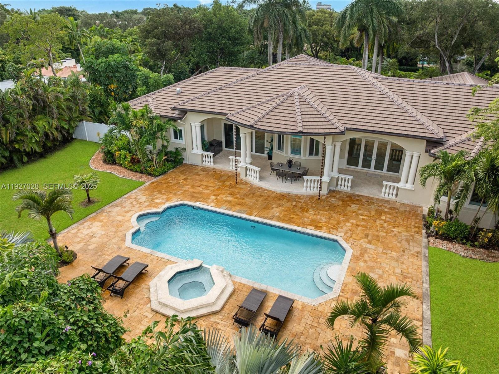Experience newly remodeled sophistication at 6890 SW 94th Street, Pinecrest, FL an exceptional one-level estate featuring high ceilings throughout, set on 1 acre of mature, beautifully curated landscape. Ideally situated in North Pinecrest on a prime, private one-way street, this residence offers unmatched convenience, surrounded by top schools including Gulliver, Temple Beth Am, and Pinecrest Elementary.

This stunning home blends timeless design with effortless, resort-style living. Expansive sun-filled interiors showcase soaring tray ceilings, elegant columns, and a seamless flow between formal and informal living spaces. Enjoy a sophisticated dining room, a spacious family room, and a beautifully updated chef’s kitchen complete with premium cabinetry, stone countertops, and a striking center island.

Generously sized bedrooms feature warm wood flooring, abundant natural light, and well-appointed bathrooms. The luxurious primary suite offers a serene retreat with its spa-inspired bathroom, including a freestanding soaking tub, large glass-enclosed shower, dual vanities, and expansive custom closets.

Step outdoors to your private tropical sanctuary: a sparkling pool and spa surrounded by lush greenery, covered terraces, and ample lounging areas perfect for both relaxation and entertaining. A long brick driveway, manicured grounds, and elegant entryways further elevate the property’s impressive curb appeal.