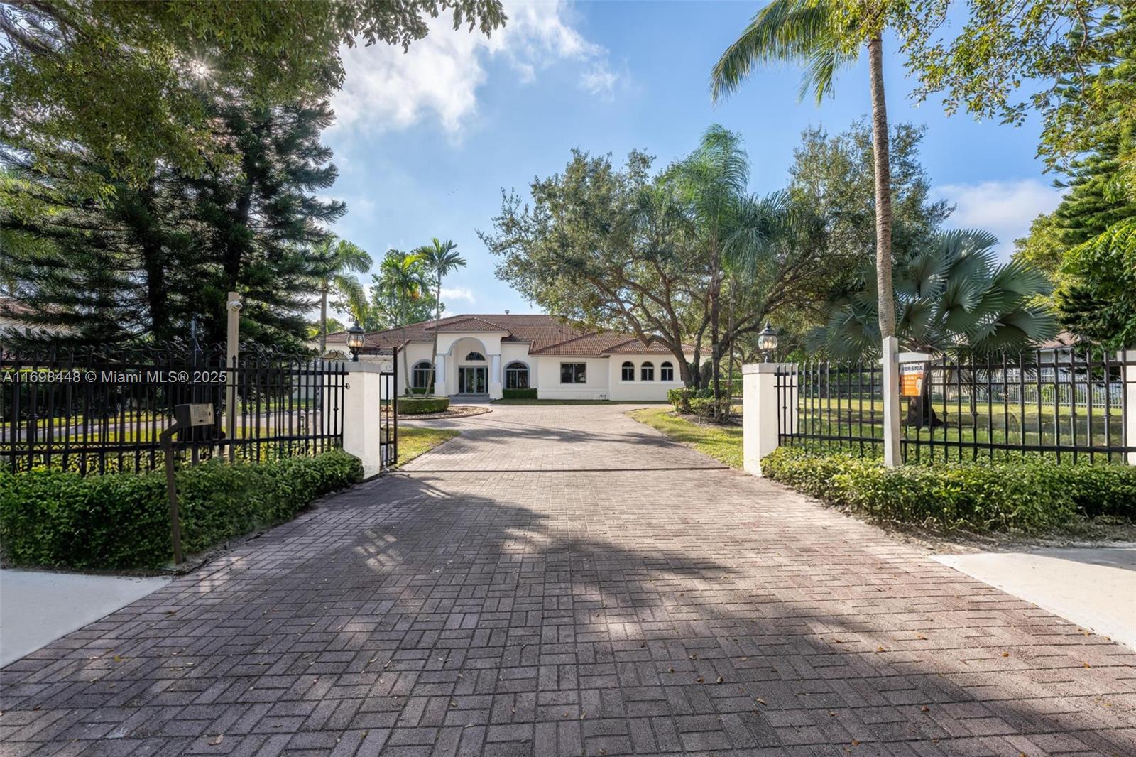 The perfect blend of space, privacy & prime location with this expansive 1.17-acre gated estate in one of Miami’s most sought-after neighborhoods. This Mediterranean-style 5-bedroom + den residence boasts 14-ft-high ceilings in common areas, impact windows throughout, & new HVAC units, ensuring comfort and durability. Designed for both elegance and recreation, the north/south-facing lot is planned to accommodate a tennis court or padel/pickleball, allowing all-day play. Generous driveway entry provides privacy, flexibility & ample room for parking, w/ a circular main driveway & separate parking area on the eastern exposure connecting to a three-car garage. With 5,011 interior SF, 7,036 total SF, & 15,395 SF of lawn space, this estate is primed to become your dream indoor/outdoor retreat.