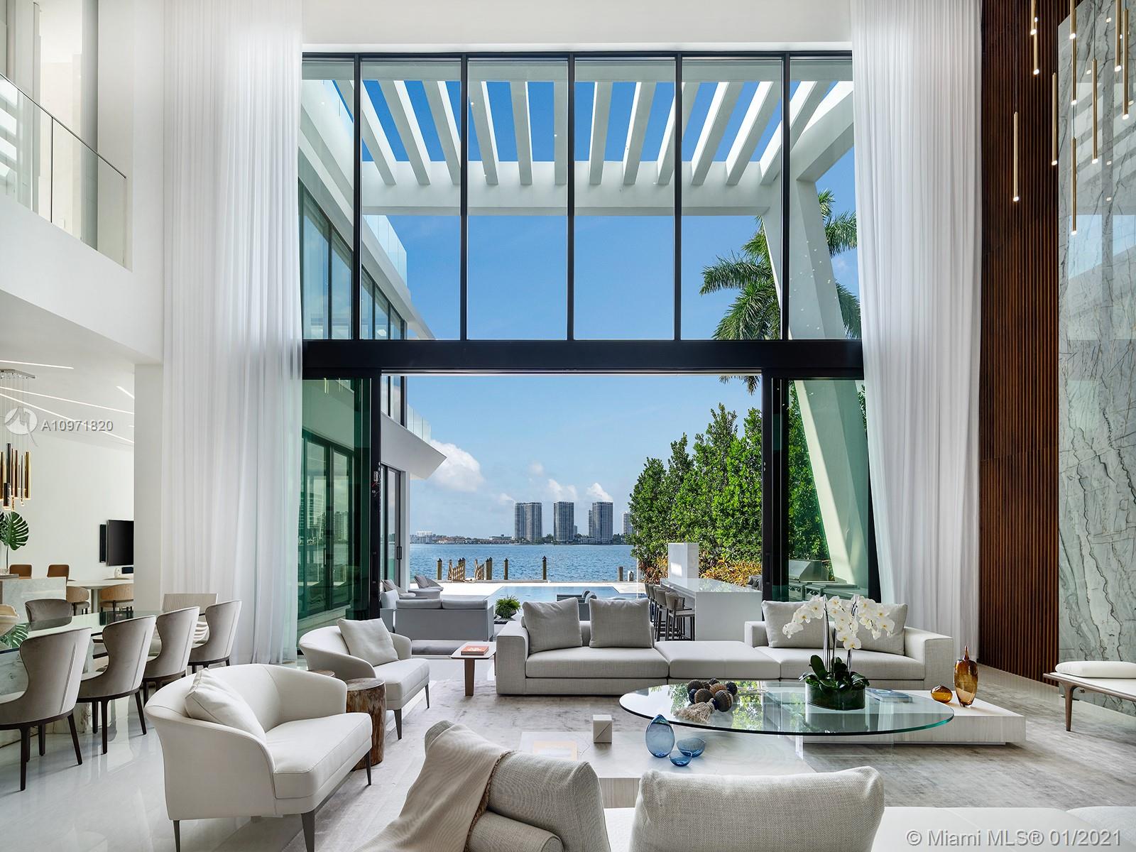 Contemporary waterfront home featuring bespoke architectural details accentuating a comfortable and opulent family residence, masterfully-crafted by architect Danny Sorogon and interior designer Steven G. A glass-box elevator, custom floating staircase, sculptural walls which cleverly disguised hidden doorways, and exotic stonework finishes set the one-of-a-kind design apart while providing every luxury amenity. Live in grand style under 27-foot ceilings and soaring glass walls, offering Intracoastal Waterway views while the Veneta Cucina chef’s kitchen could be mistaken for abstract art if not for the Wolf and Subzero appliances. Outside, tie up your showpiece yacht at the new dock and enjoy the resort-style pool, spa, summer kitchen, and oversized rooftop terrace and games deck.