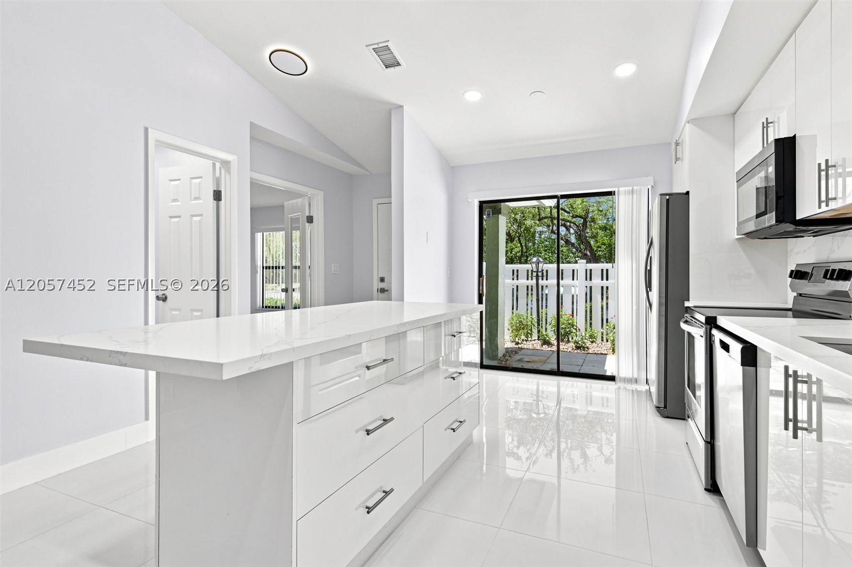 Rare opportunity at Karanda Village — a beautifully remodeled (2021) first-floor waterfront villa offering over 1,300 sq ft of thoughtfully designed living space with true lake views right from all rooms, overlooking a picturesque pond framed by mature palms. The modern, open-concept kitchen features custom cabinetry, a center island, quartz countertops, and stainless steel appliances. Both bathrooms have been tastefully updated with modern shower panels and glass enclosures. High-end 24x24 porcelain tile flows throughout with matching new baseboards, complemented by all LED lighting and an updated electrical panel (2021). Major systems recently upgraded for peace of mind: A/C (2023), tankless water heater (2025), roof (2025), and dryer (2026). Relax on the screened lanai and take in the water view year-round. The association maintains healthy reserves and includes access to the Township. Please see all attachments for more information. Don't forget to view the 3D walkthrough!