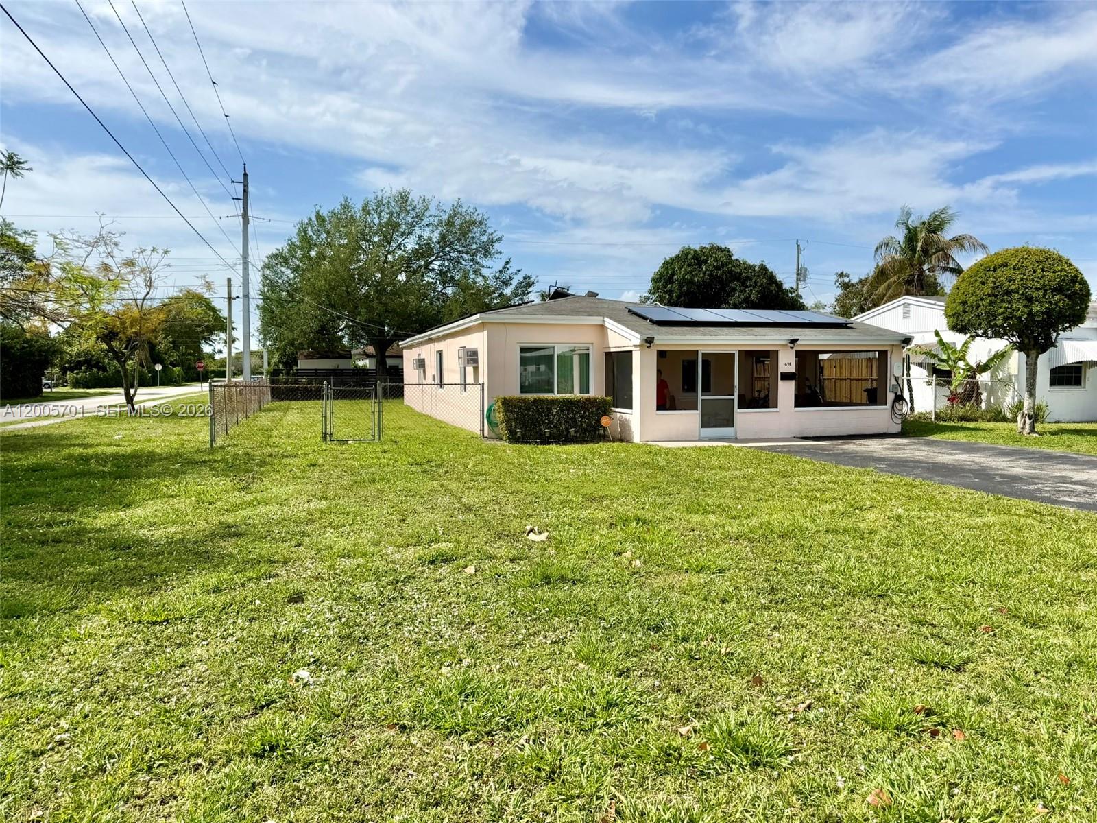 Well-maintained single-story 3-bedroom, 2-bath home in North Miami Beach, owned and cared for by a long-time owner, situated on an oversized corner lot with a fenced yard and room for a pool. This property features a large L-shaped screened porch perfect for outdoor living, a primary suite with a spacious walk-in closet and remodeled bathroom, and a functional kitchen with a stainless steel refrigerator and glass-top electric oven. Key updates include solar panels for energy efficiency, hurricane impact windows and doors, an upgraded electrical system, and a tankless hot water system. Additional highlights include a dedicated laundry room with full-size washer and dryer and the added benefit of no flood insurance required. A solid home with great bones, offering comfort, space, and potential in a desirable location.