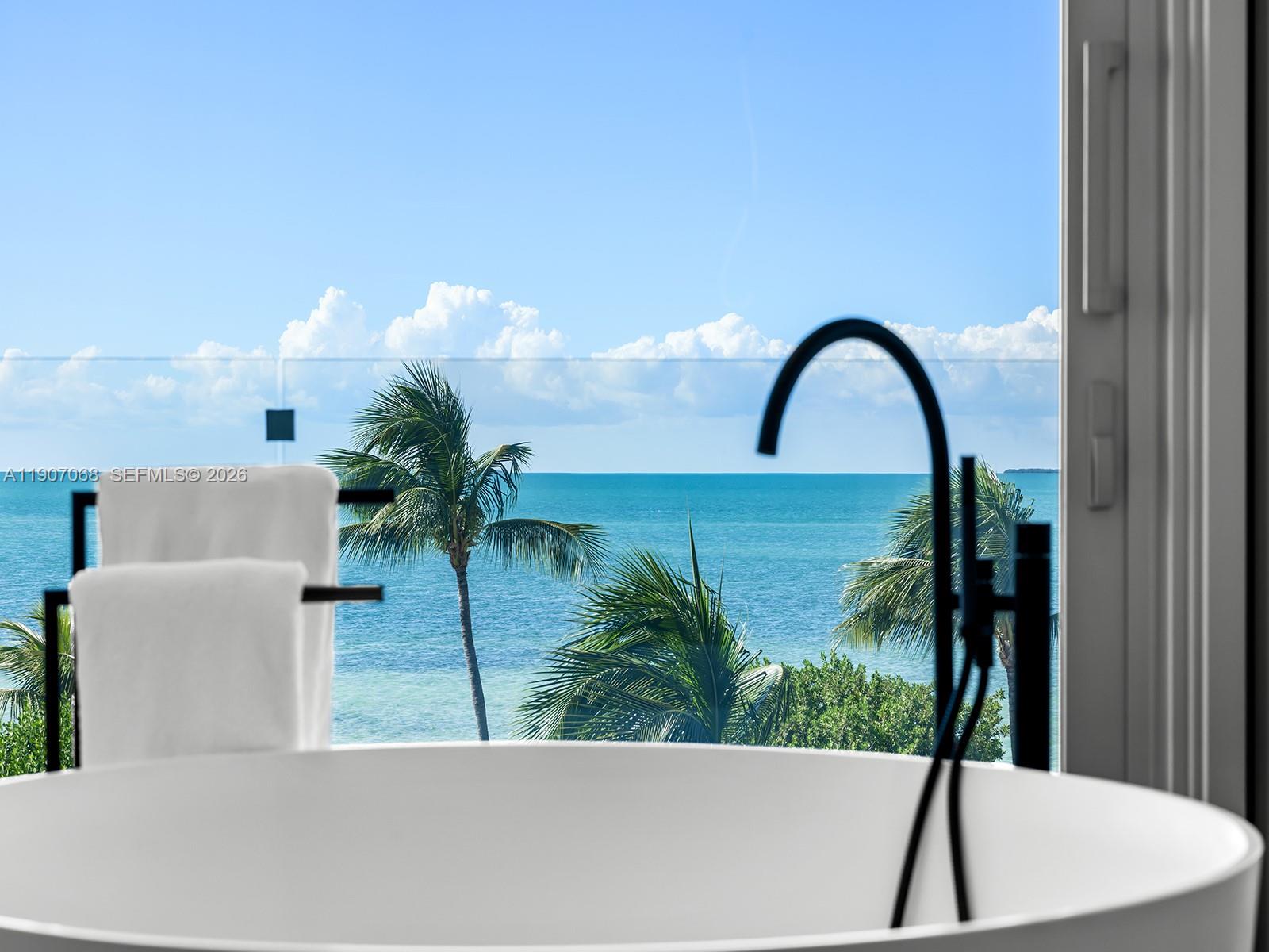 A rare architectural masterpiece by renowned architect Max Strang, this modern coastal estate in Port Antigua, Islamorada, redefines luxury waterfront living. Set on a private sandy beach, the residence offers 5 bedrooms, 6 full baths and 2 half baths across 6,367 SF of interior space and 10,483 total SF. Strang’s signature tropical modernist design showcases natural materials, clean lines, and expansive glass walls framing panoramic ocean views. Amenities include a gym, golf simulator room, movie theater living area and a spectacular summer kitchen for entertaining. Outdoor living shines with a resort-style pool, spacious terraces and direct beach access. Every detail embodies refined elegance, relaxed sophistication and the timeless allure of Islamorada’s coastal beauty. Fully furnished.