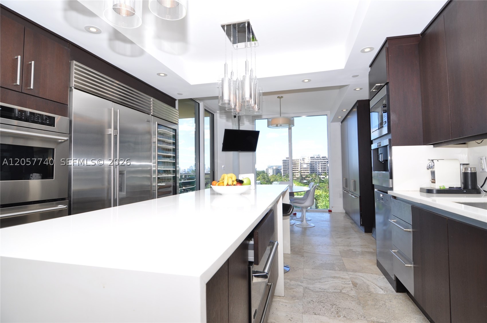 Rare opportunity in one of Key Biscayne's most sought-after buildings. This corner residence offers sweeping views of Biscayne Bay and the Miami skyline, framed by 3 balconies throughout.
The kitchen features top-of-the-line appliances, a center island and a sun-filled breakfast nook — a true chef's dream. Marble flooring flows through the expansive, open living and dining areas, ideal for entertaining, while rich dark wood grounds the bedrooms with warmth.
3 full bedrooms, 2 full baths, plus a maid's quarters with full bath. Generous walk-in closets throughout. A private entrance sets the tone the moment you arrive — your own island getaway, move-in ready.