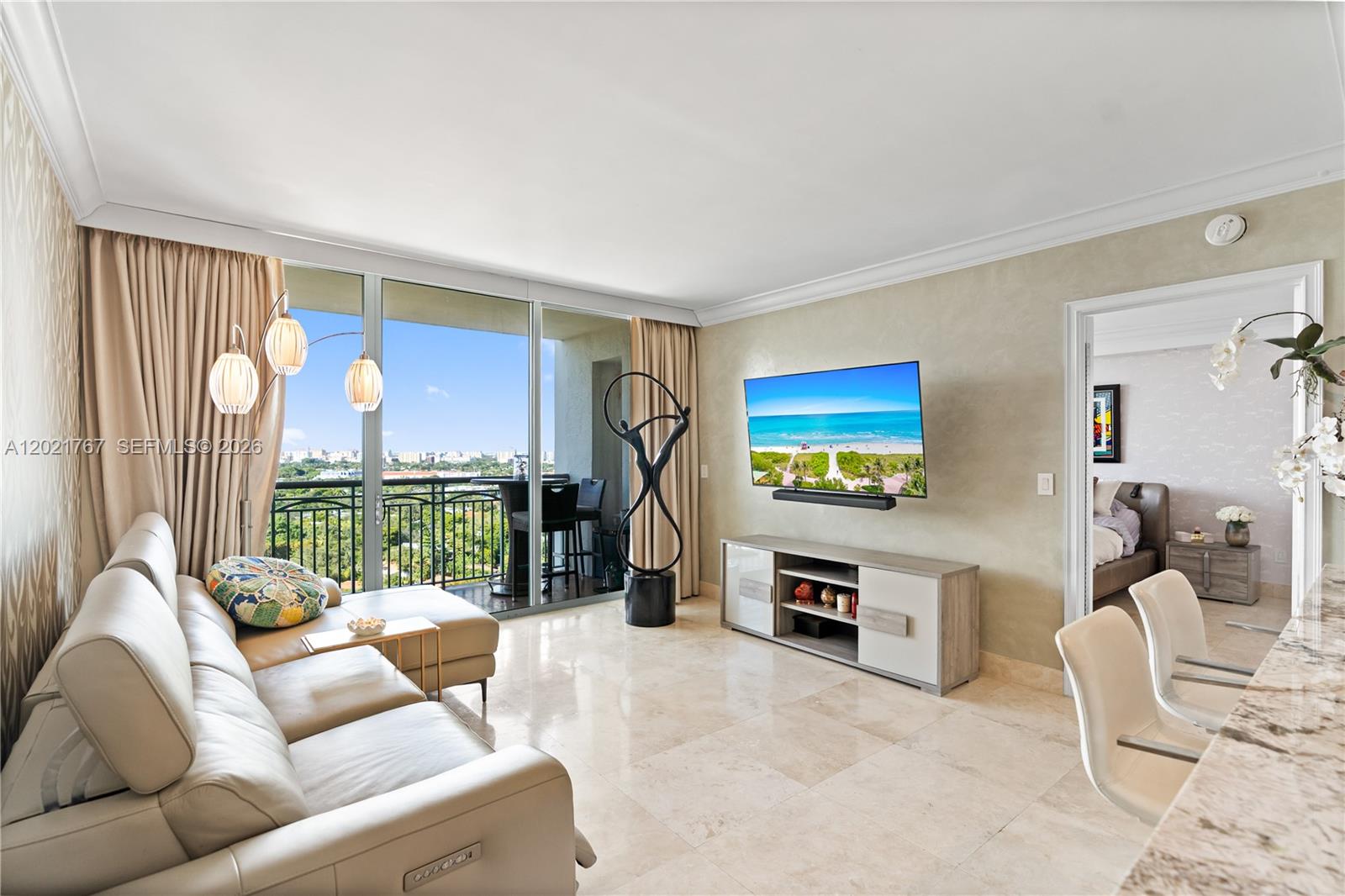 Located within the prestigious Ritz-Carlton Residences, Coconut Grove - enjoy world-class amenities including concierge service, spa access, and resort-style comforts—luxury living at its finest. Bright and tastefully designed, this residence showcases refined finishes and expansive views. Marble flooring, textured wall details, and an open-concept layout create a seamless flow throughout. The kitchen features granite waterfall countertops, custom cabinetry, and high-end stainless-steel appliances. Floor-to-ceiling glass fills the home with natural light and opens to a private terrace overlooking the Grove canopy and Coral Gables skyline. Modern lighting, sleek décor, and direct terrace access from the suite enhance the home’s tranquil, elevated ambiance.
