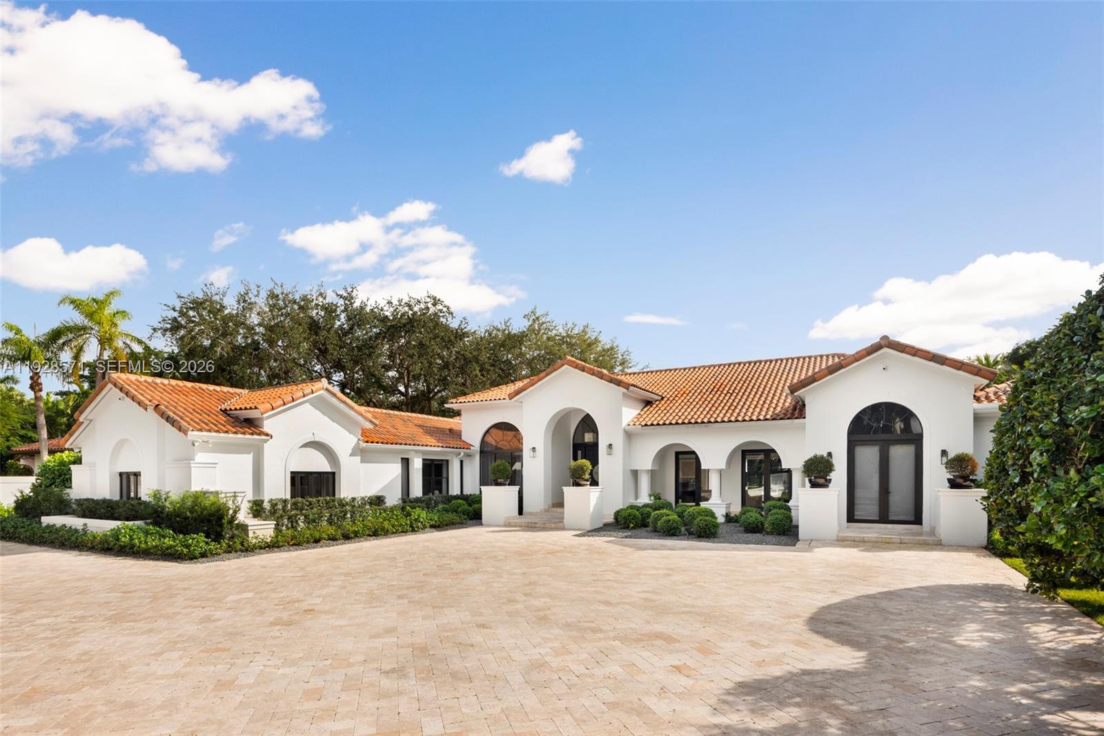 A stunning Glenvar Heights retreat defined by soaring ceilings, elegant arched windows, and a luminous, open layout that evokes a sense of timeless sophistication. Sunlight pours through custom windows, highlighting architectural details and connecting the interiors to lush outdoor surroundings. French doors, volume ceilings, and expansive living spaces foster an effortless indoor–outdoor lifestyle. The chef’s kitchen opens to the dining and living rooms, offering an inviting setting for refined entertaining or relaxed gatherings. The serene primary suite features a sitting area, pool views, and a spa-like bath with dual vanities, soaking tub, and walk-in shower. Four additional bedrooms offer flexibility, including maid’s quarters ideal for guests or a home office. Outside, a tropical oasis awaits with a resort-style pool, expansive patio, and fully equipped summer kitchen. Surrounded by mature landscaping and nestled on a generous lot, this Mediterranean-inspired residence blends privacy, scale, and character in one of Miami’s most desirable neighborhoods. Additional features include marble and wood flooring throughout, a spacious laundry room, and beautifully manicured grounds offering ample room for entertaining or peaceful retreat. With no HOA, an ideal location near top schools, and seamless access to Coral Gables, South Miami, and Pinecrest, this home offers the complete lifestyle package.