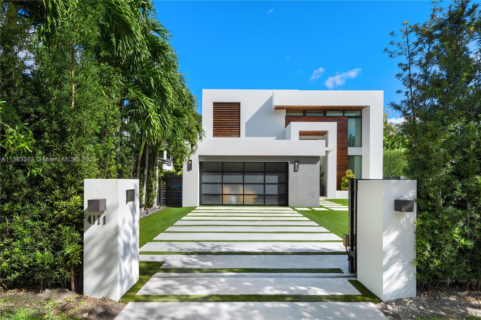 A modern beauty with spectacular finishes. Positioned in prime South Grove, this 2-story home is move-in ready with the sleek splendor you have been looking for in a Miami home. 5 total bedrooms, 4 upstairs and 1 downstairs, all en-suite with 2 guest bedrooms sharing a bathroom. Gorgeous porcelain wood-like floors throughout the entire home. Curated kitchen and walk-in wine cooler (200+bottles) with functionality and aesthetics in mind. Floor to ceiling windows allow the natural light to shine in. Covered outdoor living space with summer kitchen that overlooks the sparkling heated swimming pool with saltwater filter. Low-maintenance yard with artificial turf and native trees/plants with irrigation system. Gated and high-hedge for superior privacy. 2-car garage. Not in a Flood Zone!