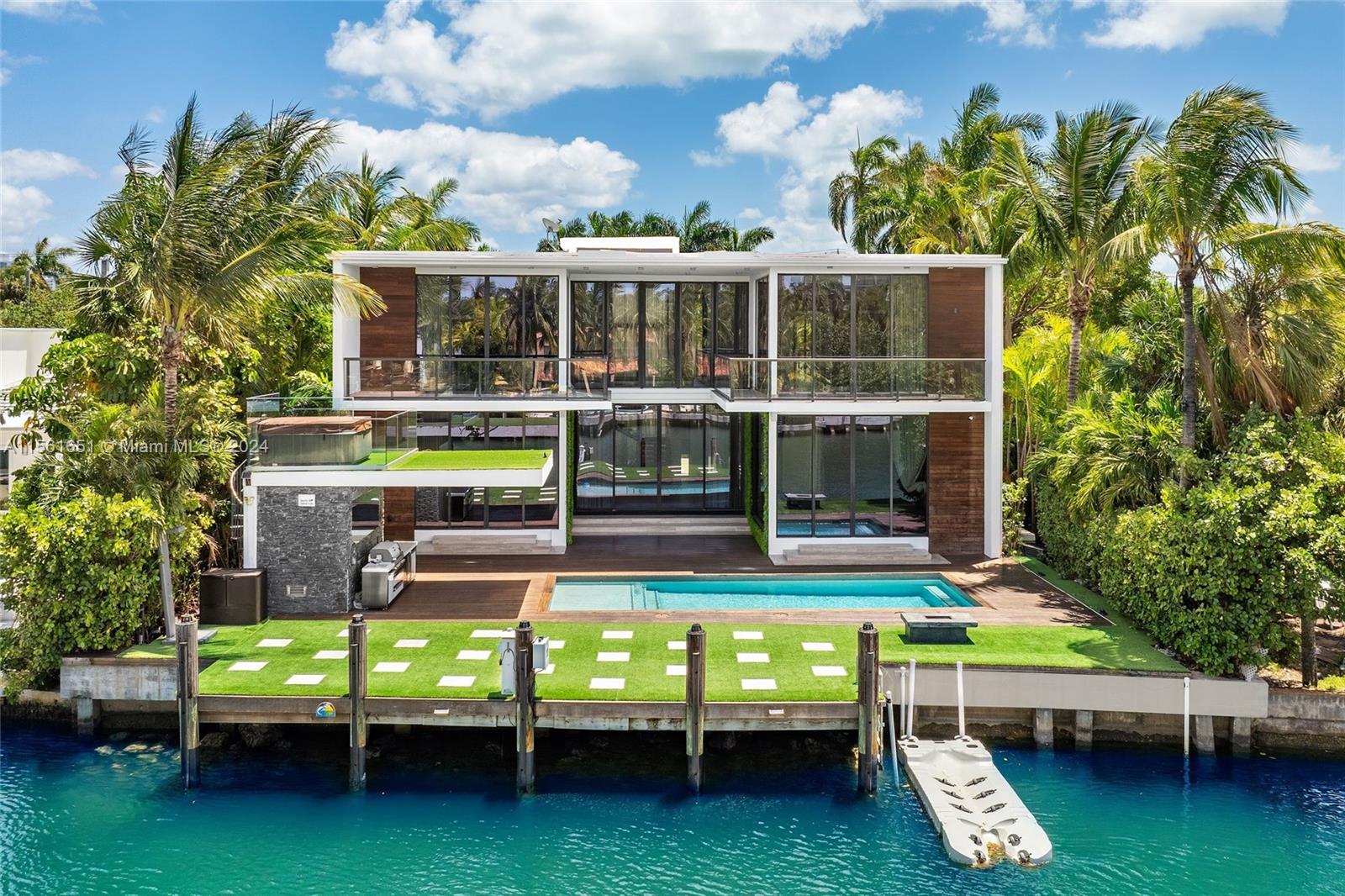 Experience modern luxury and prime location in this extraordinary Cheoff Levy Fishman masterpiece! Nestled between the Biscayne Waterway and Miami Beach Golf Club, every room offers breathtaking views. The backyard is an outdoor oasis, perfect for entertaining and relaxation, featuring terraces, a covered open-air summer kitchen, lush pool, cabana bath, and a rooftop hot tub for spectacular sunrises and sunsets. The living room impresses with a 28-ft ceiling, a gourmet Subzero-Wolf marble kitchen, a 12-person dining room, and a fabulous family room. Upstairs, the 1500 sqft primary suite provides a private retreat with three terraces and spacious closets. Plus, enjoy the convenience of parking for 12 cars, including a 4-car AC garage. Your dream home awaits!