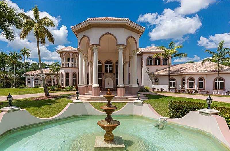 Extraordinary custom-built estate situated on over 5 private acres in prestigious West Boca Raton. Built in 2002, this magnificent residence offers more than 10,000 square feet of living space designed for luxury living, privacy, and grand-scale entertaining.

A breathtaking marble-clad grand foyer welcomes you with a dramatic double wrap-around staircase featuring elegant wrought-iron railings, creating an impressive architectural centerpiece. The expansive floor plan includes formal living and dining rooms, a spacious family room, and a large chef’s kitchen with breakfast bar, ideal for gatherings and entertaining.

The luxurious primary suite serves as a private retreat, complete with a raised soaking tub, dressing room, and spa-like bath. The estate also features five additional bedrooms and multiple bathrooms, offering ample space for family and guests.

Step outside to enjoy a true resort-style setting with a spectacular pool and spa, expansive patio areas, and beautifully landscaped grounds. Additional amenities include two guest homes, private tennis courts, and horse stables, making this exceptional property ideal for equestrian enthusiasts or those seeking a private compound lifestyle.

A rare opportunity to own a luxury estate offering space, privacy, and world-class amenities in the heart of West Boca Raton.
