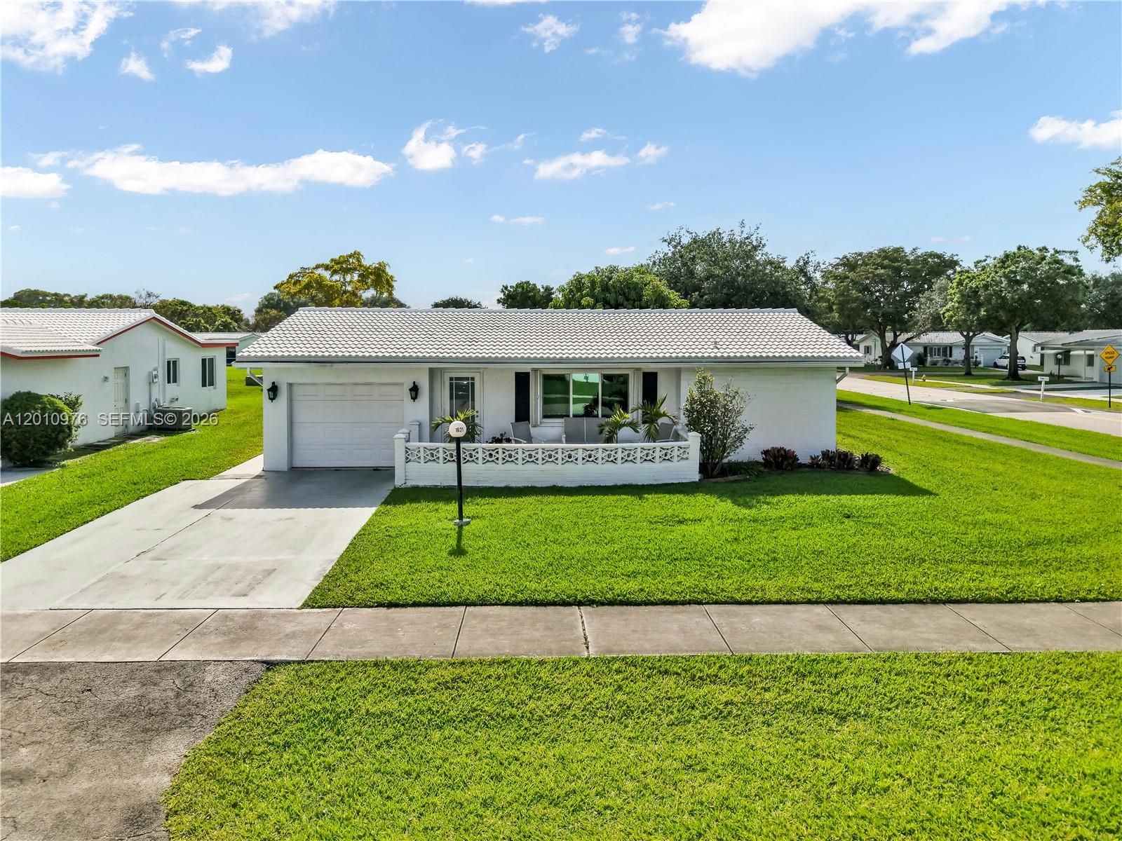 Welcome to this beautifully renovated oversized corner-lot home in a highly sought-after 55+ community. This 2-bedroom, 2-bath residence features a desirable split-bedroom layout, one-car garage, and double-wide driveway. Step inside to a bright, open interior with an updated kitchen offering custom white cabinetry, granite countertops, stainless steel appliances, and pantry. Tile flooring throughout, designer blinds, full-size washer and dryer with laundry tub, and a new GE electrical panel add to the home’s move-in-ready appeal. The oversized primary suite is a true retreat with a renovated bath, double-sink vanity, walk-in closets with custom built-ins, and a spacious en-suite. Enjoy indoor-outdoor living with two rear patios—one screened and one open—accessible from the primary bedroom, dining, and family rooms. Full storm protection with impact windows and accordion shutters provides peace of mind. Resort-style amenities include a clubhouse, two pools, tennis courts, fitness center, entertainment, and courtesy bus service. Association covers fiber optic HD TV, internet, lawn care, roofs, exterior painting, and more. Prime location near shopping, dining, hospitals, and major transportation. Move-in ready and easy to show. Schedule your private tour today.