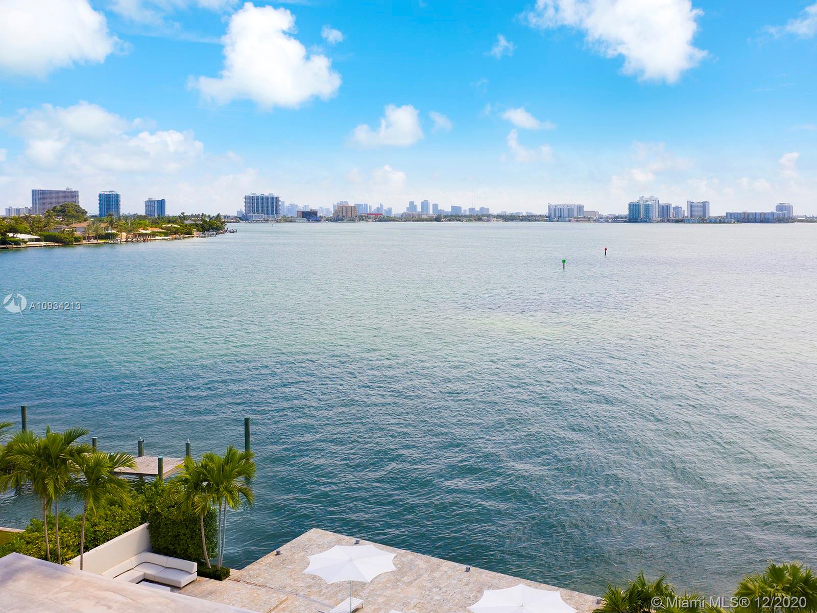 This home’s lot has the best views on the island! Located at the tip of guard gated Biscayne Point in Miami Beach, you’ll marvel at the panoramic open bay and downtown views. Watch amazing sunsets and city lights from the expansive sliding glass doors of this stunning MiMo. A large 12,150 sq. ft. lot on 100 feet of waterfront and over 1,100 sq. ft. of tiled dock offers a backyard oasis with pool, spa and cabana bath. Open floor plan has book-matched Calcutta marble and limestone. Professional kitchen boasts Boffi cabinets, Nero Portoro marble and appliances from Miele, Subzero, and Gaggenau. Primary includes custom walk-in Ornare closet, marble bath and steam shower. The property has Savant home automation, a backup generator, and is surrounded by a gated 6 ft. wall for complete privacy.