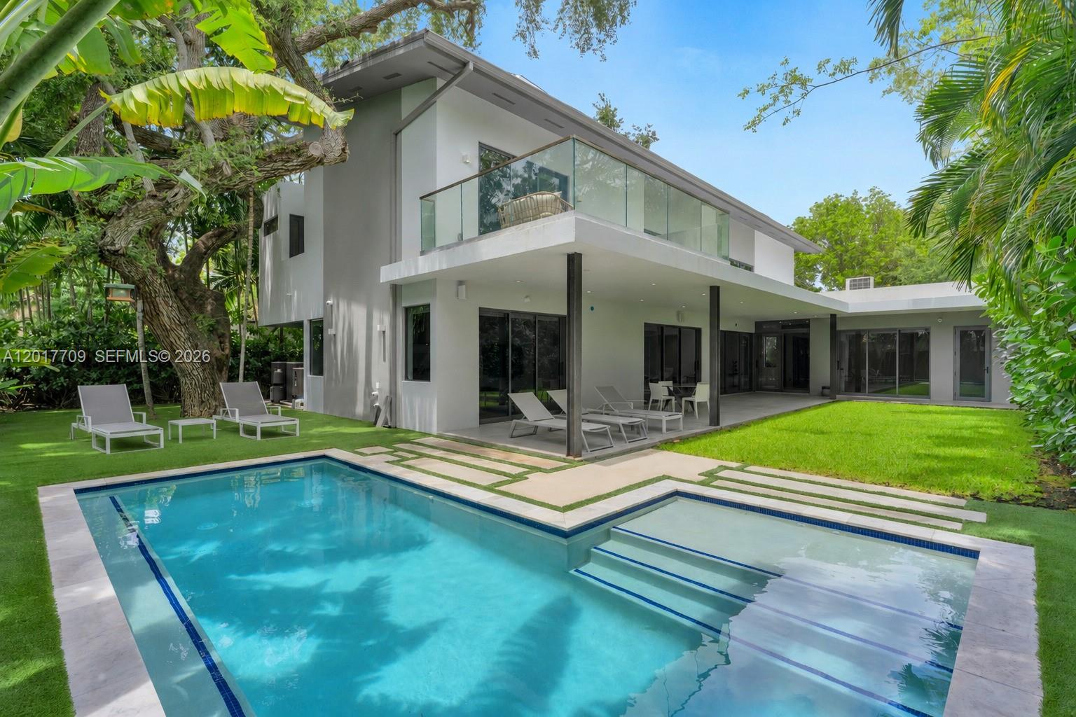 Nestled in the exclusive enclave of North Coconut Grove in BAY HEIGHTS, this exceptional new modern construction redefines luxury living with striking architectural design and refined contemporary finishes throughout. A dramatic double-height entry and soaring ceilings create an impressive sense of scale, while walls of glass flood the residence with natural light. Offering 5 spacious bedroom suites, a dedicated staff/maids room, 6 full baths, and a powder room, the thoughtfully designed layout blends elegance with functionality. Designed for both grand entertaining and everyday living, the home features expansive living spaces including a family room, second-floor loft/lounge area, oversized covered terraces, and seamless indoor-outdoor integration surrounding the resort-style pool. Sophisticated Porcelanosa concrete flooring flows throughout, complemented by a bespoke Italian kitchen by SCIC Italia equipped with premium Miele appliances. The luxurious primary suite offers a spa-inspired bath complete with a private outdoor shower immersed in lush tropical surroundings. Additional highlights include custom walk-in closets, lacquer-finish interior doors, a magnificent wood pivot entry door, LED lighting throughout, generous storage, pantry, laundry room, and impeccable attention to detail throughout this exceptional residence. Close proximity to Brickell & Downtown Miami just 7 minutes away, and only 15 minutes to Miami International Airport.
