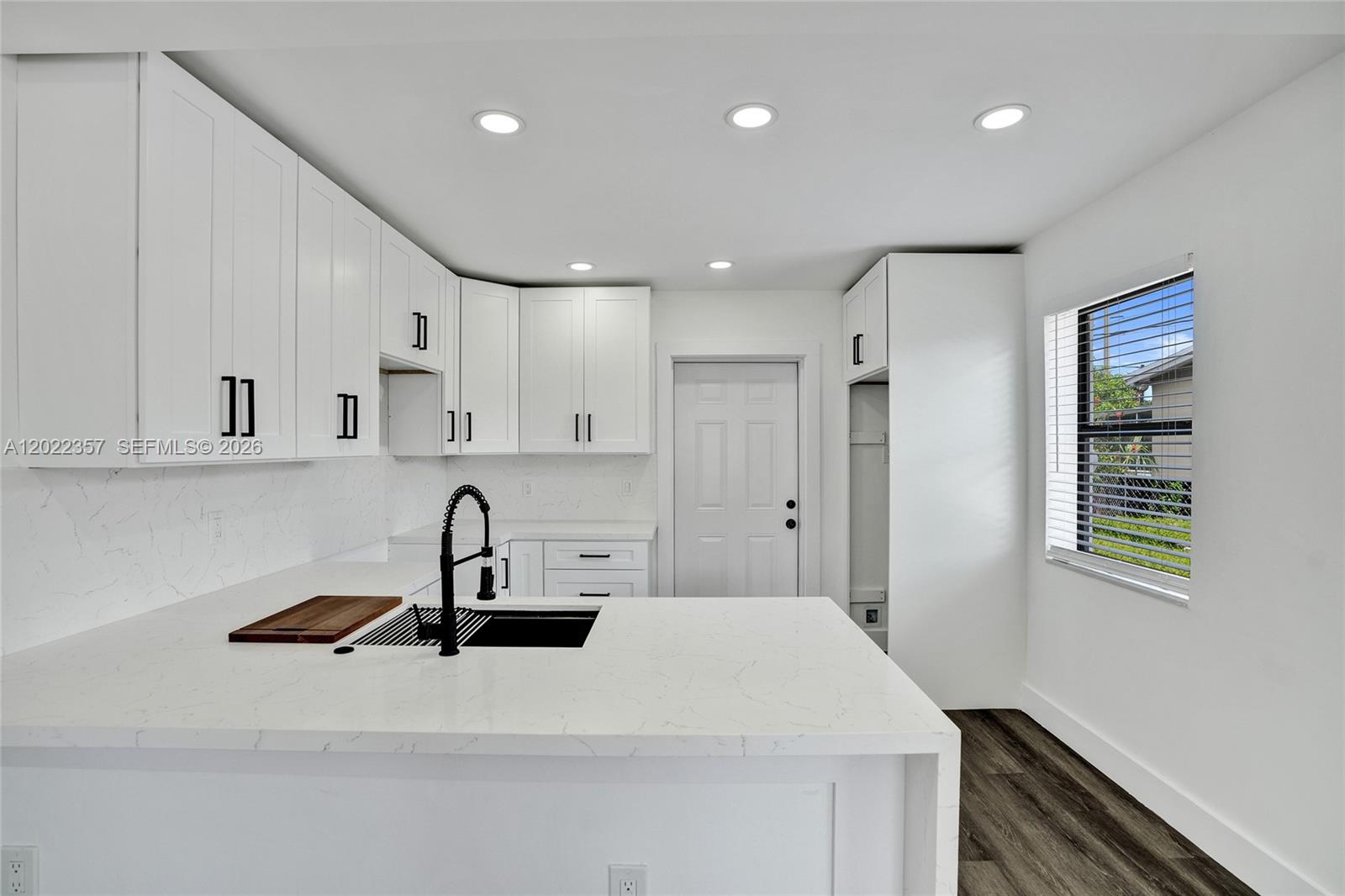 Welcome to 733 NW 15th Terrace, Fort Lauderdale, FL 33311! This beautifully renovated 2-bedroom, 1-bath home features a bright open-concept layout with modern finishes throughout, including a stunning kitchen with white cabinetry, quartz countertops, a spacious peninsula with seating, and sleek black fixtures, all complemented by recessed lighting and large impact windows that fill the space with natural light; both bedrooms are well-sized, the bathroom is fully updated with elegant tile work and contemporary finishes, and additional upgrades include new flooring and mini-split A/C units, while outside, the property sits on a generous lot with a large backyard offering endless potential, a long driveway for ample parking, and a fenced front yard for added privacy, all conveniently located near major highways, shopping, and dining—perfect for homeowners or investors alike.