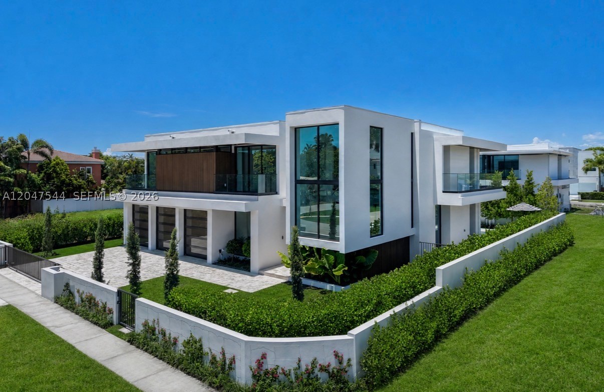 Experience elevated living at this exceptional newly completed residence by Empire Development, offering 6,641 total sqft of contemporary luxury in the heart of East Boca Raton. Beyond a fully gated entrance, a dramatic 24 FT foyer welcomes you into expansive open living spaces finished w/ 48” x 48” imported Italian porcelain, soaring ceilings, & walls of glass. A custom white oak staircase leads to a second level featuring wide-plank white oak flooring throughout. The home offers five ensuite bedrooms in the main residence, a private office, & an expansive primary suite w/ spa-inspired bath showcasing full marble shower & marble vanities. The chef’s kitchen is anchored by rare natural stone quartzite & top of the line appliances. A detached guest house w/ a full bedroom & bath, separate cabana, 3 car glass garage, & thoughtfully designed architectural details elevate the home’s exceptional design. The resort-style backyard features a saltwater pool & spa, creating the perfect setting for year-round South Florida living. Ideally located just minutes from Mizner Park, The Boca Raton, world-class dining, shopping, private clubs, and Boca Raton’s pristine beaches, 1099 NE 4th Ave presents a rare opportunity to own one of East Boca Raton’s finest newly completed luxury residences.