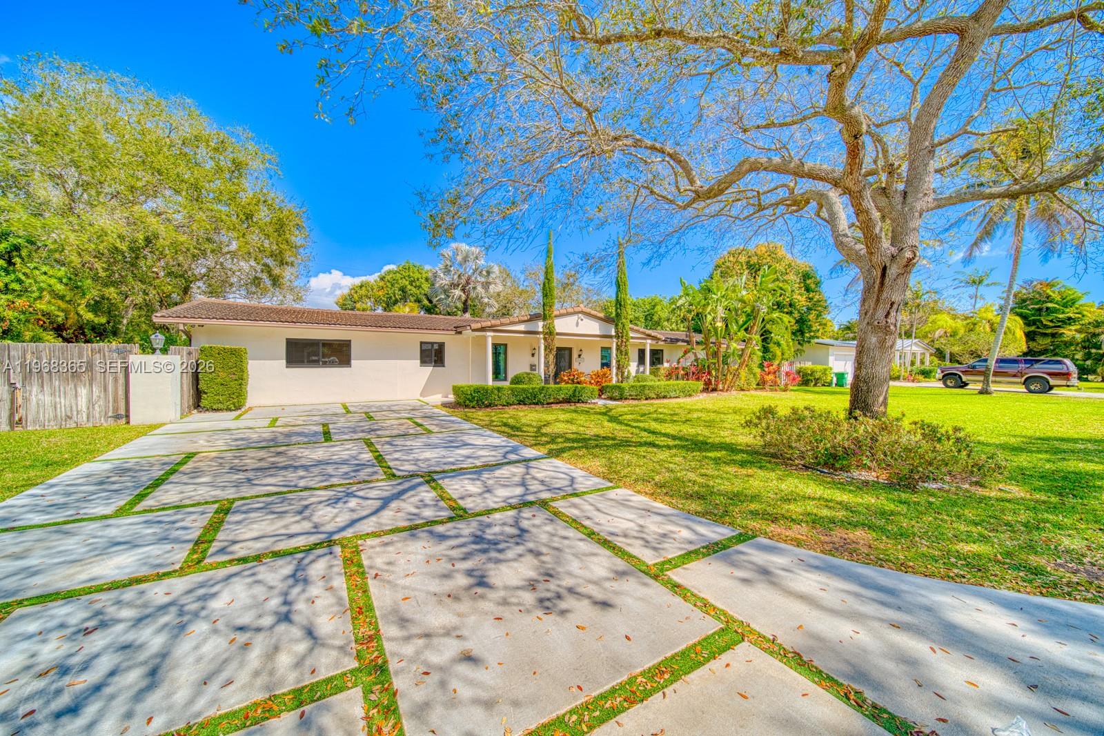 Tucked beneath majestic oak trees and filled with natural light, this beautifully renovated home offers exceptional indoor-outdoor living in a highly desirable neighborhood close to Coral Reef Park, and A-rated schools.The backyard is a true retreat, featuring a resurfaced pool with a rare 9-foot depth, perfect for entertaining or relaxing. An outdoor kitchen and bar area, new turf, and lush clusia hedges provide privacy and an inviting setting, while landscape lighting highlights both the front and back yards for stunning evening ambiance.Inside, nearly the entire home has been thoughtfully updated. Oversized 3’ x 3’ tile flooring flows throughout, creating a seamless, modern feel. The 2018 kitchen renovation includes quartz countertops, custom cabinetry with Blum soft-close hardware, under-cabinet lighting, lazy Susan, spice rack, and updated appliances. Major upgrades include a new roof, hurricane-impact windows and doors, updated plumbing, added insulation, recessed lighting, and multiple A/C systems, including a mini-split in the back bedroom.The remodeled hall bath features new tile, tub, vanity, and fixtures, laundry area includes a sink and stackable washer/dryer.Additional highlights include a turf-and-concrete driveway, and updated front porch tile. Friendly neighbors and a strong sense of community complete the experience.Move-in ready and designed for both comfort and entertaining—this home is a must-see.