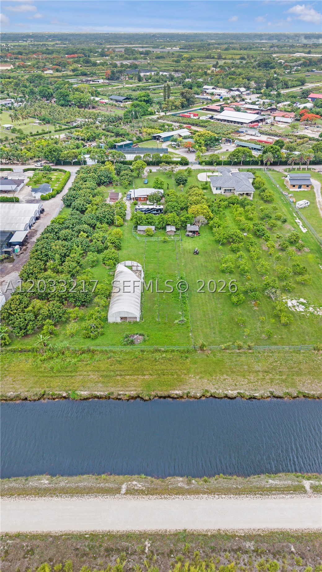 Exceptional opportunity to own approximately 2.4 fenced acres in the unincorporated area of Homestead, Miami-Dade County. This agricultural-zoned property features a thriving assortment of mature fruit trees, including avocado, mango, papaya, plantain, and many other varieties. The property is equipped with a water well, sprinkler/irrigation system, and septic tank, providing the infrastructure needed for agricultural operations or a private agricultural retreat. Additional improvements include living quarters with a bathroom and mini-split A/C, a concrete pad area suitable for trailers, equipment, or storage, and scenic canal frontage/views. The fully fenced parcel offers privacy, functionality, and endless possibilities for farming, gardening, recreation, or future agricultural use. Conveniently located in Homestead with easy access to major roadways while maintaining a peaceful rural setting.