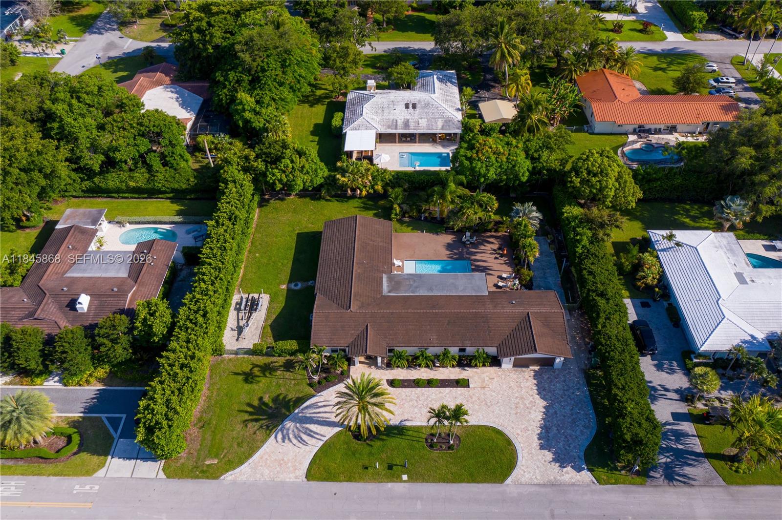Impact windows/doors. 2018 concrete roof tile. Exceptional 4/3 Palmetto Bay home designed for comfort, entertaining, and outdoor living. Ideally located near top-rated public/private schools, parks, shops, and bike paths in a quiet residential area. The spacious primary suite features his and hers walk-in closets, an updated in-suite bath with dual showers/sinks, and its own tankless water heater. The large kitchen boasts wood cabinetry, granite countertops, and an L-shaped counter with seating capacity for 4. Open living, dining, and family areas offer easy flow, with French doors throughout connecting indoor and outdoor spaces. Includes oversized 2-car garage, dedicated laundry room with cabinetry and utility sink. Short term leaseback agreement preferred.