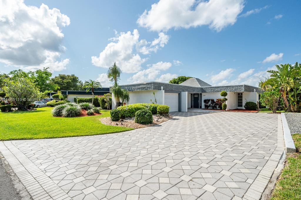 Don't miss this incredible opportunity to own this beautiful 3/2 lakefront home in the Woodlands Country Club area of Tamarac! Enjoy beautiful, wide lake views the moment you enter the home! Split bedroom plan with a master bedroom that has additional sitting area which can easily be used as either a small office, additional walk-in closet area or child's playroom. Neutral tile throughout, stainless steel appliances, gas range, electric tankless water heater, newer washer & dryer, accordion hurricane shutters/panels, updated electrical panel, large pavered driveway for additional parking, BRAND NEW ROOF! Ideally situated close to dining, schools and major expressways!