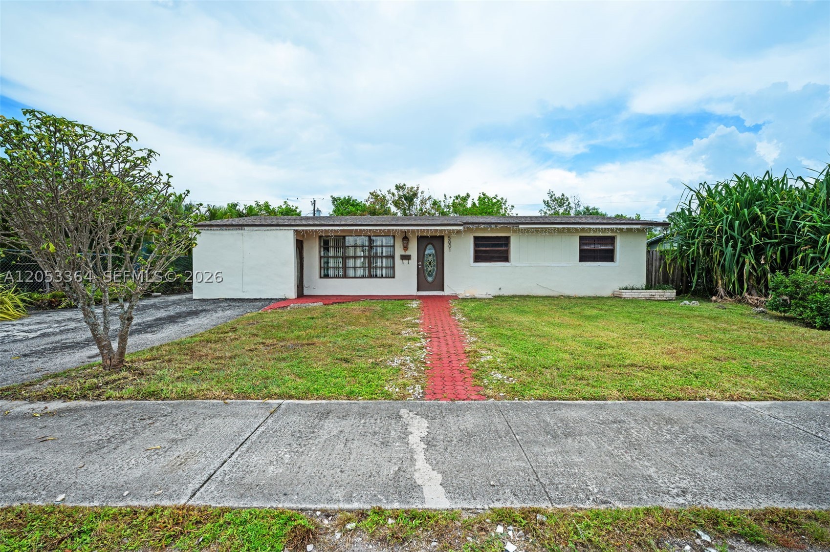 Opportunity knocks with this 3-bedroom, 2-bath single-family home offering excellent potential for buyers, investors, or anyone ready to create a space of their own. The interior features a spacious living area with tile flooring and a kitchen with granite countertops and abundant cabinetry. Outside, enjoy a large fenced backyard with mature tropical landscaping, a covered patio, and plenty of room to entertain, garden, or design your future outdoor retreat. A long driveway provides convenient off-street parking. Ready for renovation, this property offers an excellent opportunity to customize and add value. Conveniently located near parks, shopping, dining, major roadways, and just minutes from Hard Rock Stadium, home to major sporting events, concerts, and entertainment. Bring your vision and make this home your own!