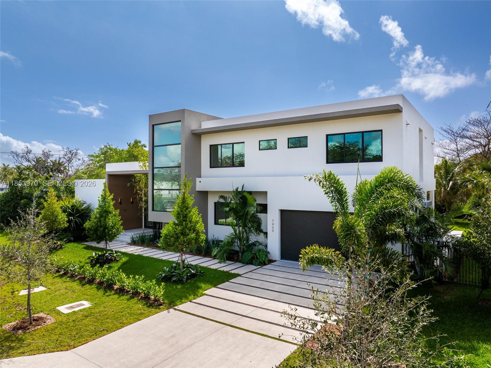 Introducing a distinguished new construction on a premier corner lot in the heart of Pinecrest, where timeless elegance meets modern design. This two-story residence features soaring ceilings, a grand entry, impact windows, custom Coblan cabinetry, and a chef’s kitchen with Miele appliances. The expansive great room opens to a sleek modern pool and covered terrace, perfect for entertaining. Two bedrooms on the main level, one with a private entrance, provide ideal accommodations for guests or multigenerational living. Upstairs, three en-suite bedrooms accompany a luxurious primary suite with a spa bath, oversized closet, and private terrace. A two-car garage and future-ready smart home integration complete this exceptional offering.
