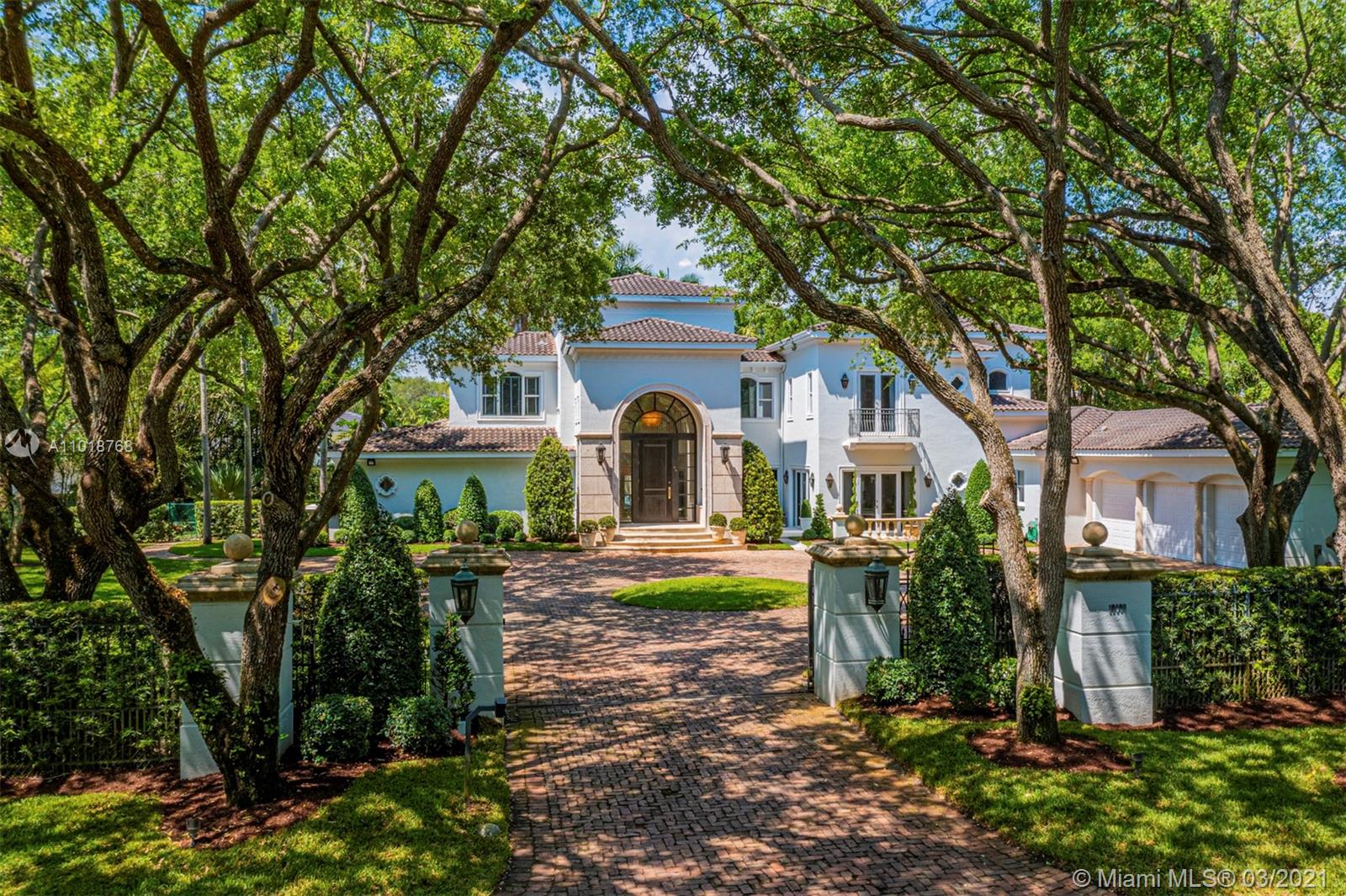 Impeccably designed residence with coffered ceilings, crown moldings, light-filled living spaces, elegant finishes and resort-like gardens.  A gated entrance surrounded by a canopy of Oak and Podocarpus trees welcomes you to this two-story 7,995 Sq. Ft. home with 7 bedrooms, 4 full and 2 half baths.  The entrance foyer leads to the formal living room,  with views of the pool and manicured garden.  Also on the main level is a formal dining room, stylish bar and professionally equipped kitchen with breakfast area. The sunny family room opens to a beautiful and sophisticated outdoor terrace, ideal for entertaining. The main suite has 2 custom-designed walk-in closets and a luxurious bathroom.  This truly remarkable home also comes with an office, gym, staff room and half-basketball court.