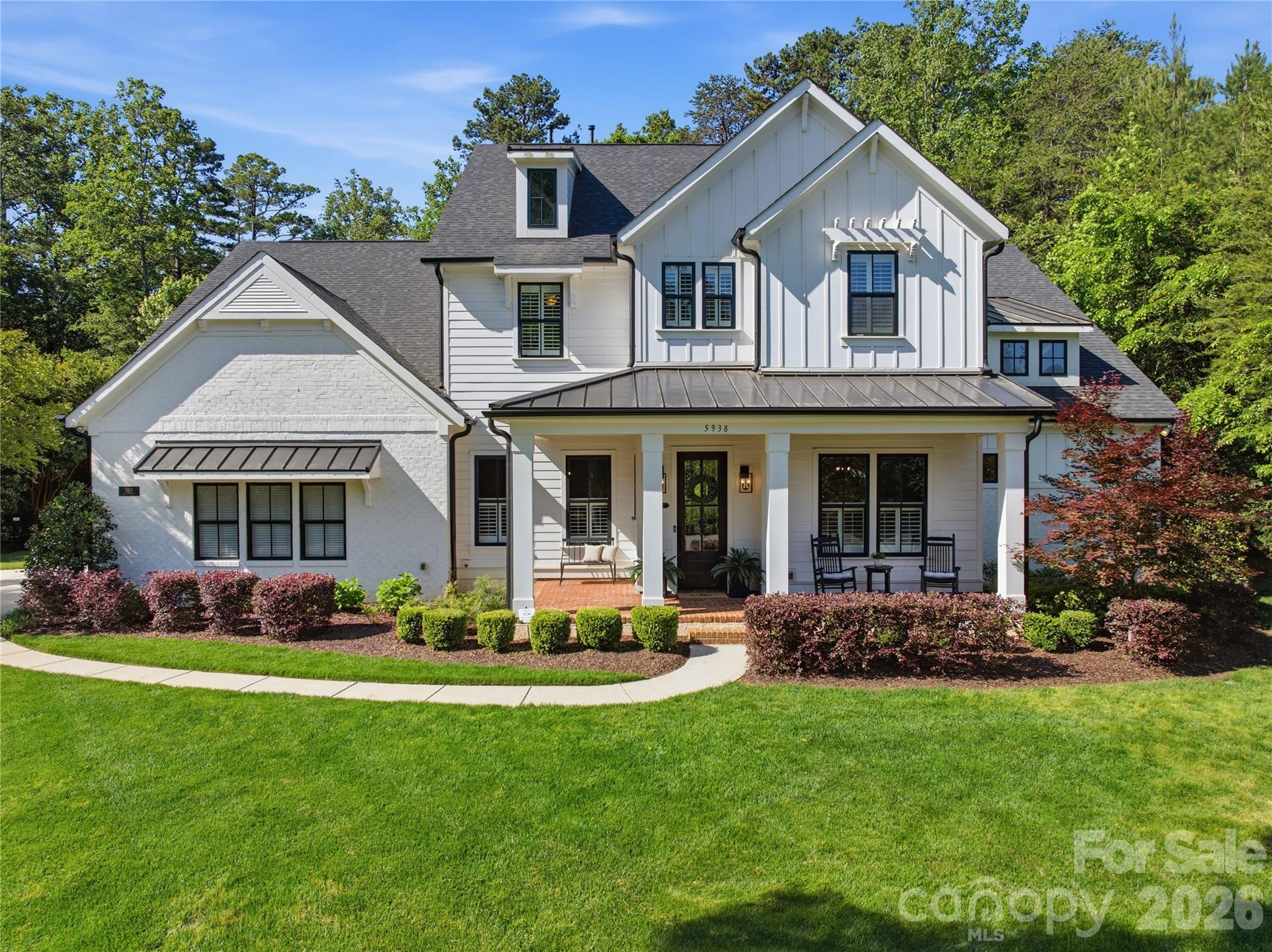 Designed by award-winning architects Deryl Paterson and Tom Devine, this 4,380 sq ft modern farmhouse sits on 1.06 partially wooded, fully fenced acres in Huntersville with city water and sewer. The family room opens to a 20-foot ceiling with barnwood beam details and a floor-to-ceiling stone fireplace with a reclaimed barnwood mantle. The kitchen is built around a KitchenAid 6-burner dual-fuel commercial range with griddle, 48" built-in refrigerator, 2 dishwashers, separate wall oven and microwave, quartz countertops, and an island with seating. The main-floor owner's suite includes a sitting room with gas fireplace, freestanding soaking tub, 6x6 shower with four shower heads, and separate his-and-her vanities. Upstairs: three bedrooms, two full baths, a large bonus room, and finished conditioned storage, with kitchen cabinets, sink and beverage fridge. Paneling in the dining room. Dutch door and barnwood trim in the mudroom. 7" hardwood floors on the main level. Pottery Barn lighting throughout. 400-amp electrical service. Two separate high-efficiency Lennox HVAC systems. Outside: covered front porch, screened in back patio with wood-burning stone fireplace and exposed wood ceiling, uncovered brick paver patio with gas grill stub, and a yard with room for a pool. Five minutes to Lake Norman at Blythe Landing, ten minutes to Birkdale Village, twenty minutes to Charlotte Douglas.