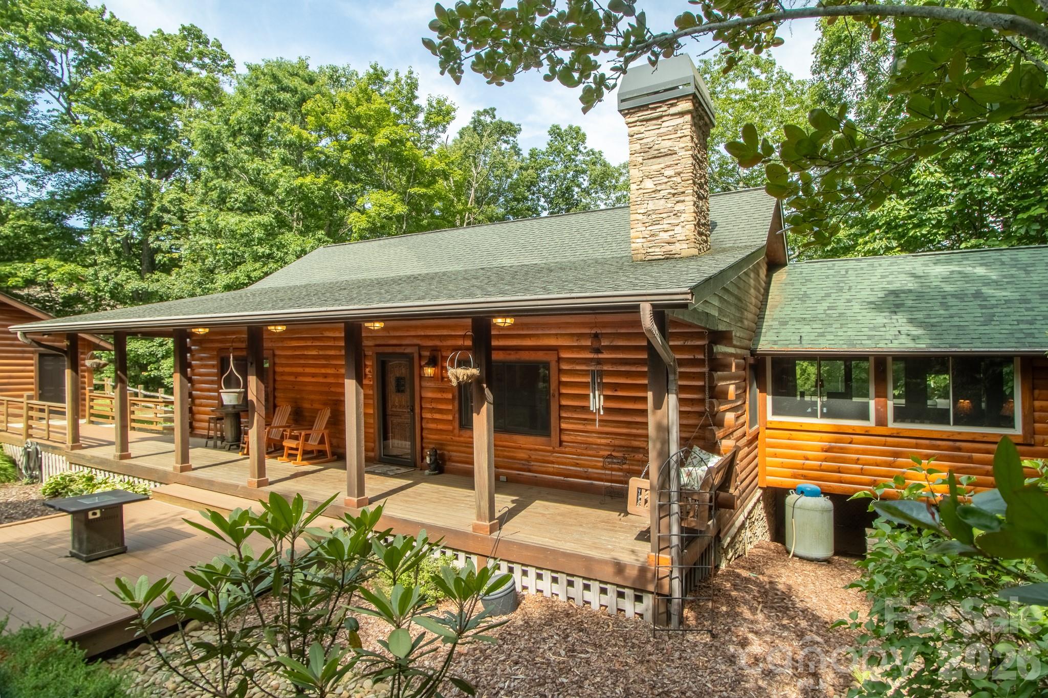 Wake up to mist in the treetops, coffee on a covered deck, and the kind of quiet most people drive a long way to find. This three-bedroom, three-and-a-half-bath log home sits on a private wooded acre in Brevard, minutes from DuPont State Forest and a short drive from downtown.
The main level is built for easy one-level living. An open great room anchors the home with a floor-to-ceiling stone fireplace, vaulted tongue-and-groove ceilings, and warm hardwood floors. The kitchen flows into the dining and living areas with a center island, breakfast bar, and granite counters, while walls of windows pull the mountain views inside. A sunroom flex space with an entertainment bar that opens to the deck, complete with powered awnings. The primary suite on the main level means you never have to take a stair to live comfortably.
Downstairs, a fully finished walk-out lower level gives guests their own retreat: a second living area, a private bedroom suite with en-suite bath, an additional bedroom and full bath, and its own covered deck.
Outside is where this one shines. Multiple covered decks and porches frame the mountain and wooded views, and an oversized detached garage adds a true workshop plus a separate bay made for a golf cart, kayaks, bikes, or fly fishing gear, exactly what the DuPont lifestyle calls for.
You are minutes from waterfalls, hiking and cycling trails, trout streams, and Sherwood Forest Golf Course, with Brevard's restaurants, music, and arts scene a short drive away. Offered tastefully furnished and turnkey, it works just as well as a full-time home, a seasonal escape, an easy lock-and-leave, or a short-term or long-term rental investment. Come see it before someone else does.