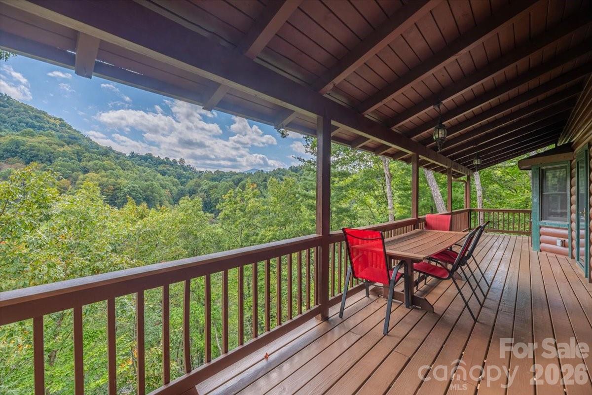 This warm and inviting, solidly built custom log home is furnished and move-in ready! Conveniently located just minutes from Historic downtown Waynesville and the Waynesville Inn and Golf Club, you will enjoy easy year-round access on wide paved city roads, city water, city sewer, plus the convenience of all city services in a peaceful setting. Enjoy year-round mountain views without the climb! The main level offers a seamless, open-concept layout highlighted by a dramatic two-story Great Room with vaulted ceilings and a stunning stone fireplace with wood stove insert. The spacious kitchen is well-appointed with solid-surface countertops, abundant cabinetry, and generous workspace, flowing effortlessly into the inviting dining area—ideal for entertaining and everyday living. The primary suite is conveniently located on the main level and includes an updated bath with a walk-in tile shower. Outdoor living is enhanced by an expansive back deck offering beautiful mountain views, perfect for entertaining, relaxing, and enjoying cool mountain evenings. The upper level includes a comfortable family room, two generously sized bedrooms, a full bath, and a flexible bonus room suitable for a home office, hobby space, or additional sleeping area. The lower level offers excellent additional living options, including a complete one-bedroom apartment with a living room, full kitchen, full bath, and a private deck—ideal for guests, live-in help, or multi-generational living. Additional features include an oversized two-car garage with workshop space and a covered shed. Whether used as a primary residence, seasonal getaway, or potential vacation rental, this well-appointed log home offers outstanding comfort, flexibility, and location. The three lots give you additional options. The community has a playground, tennis courts, and pickleball courts for residents and guests.
