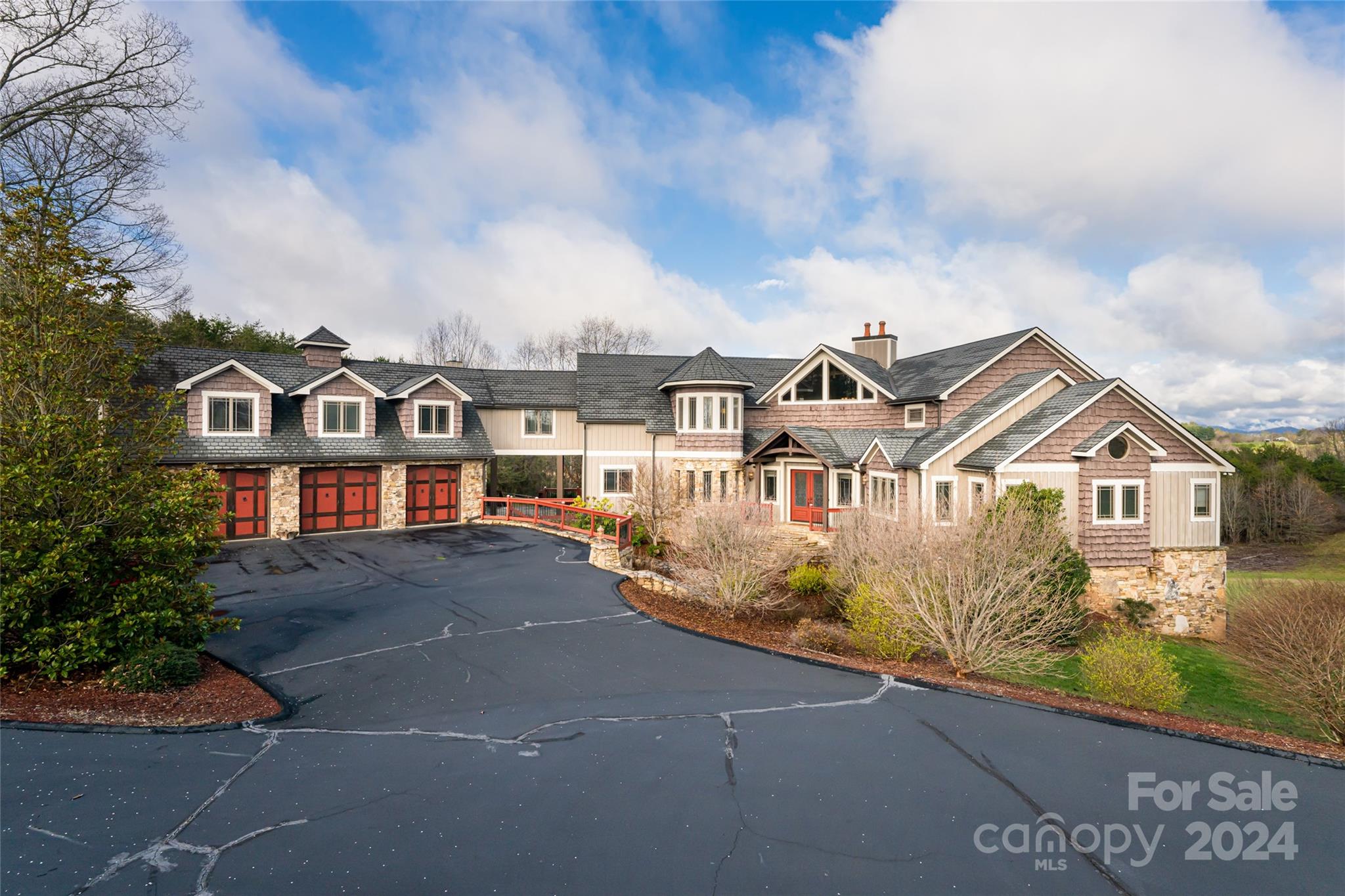 Paint a picture of an exquisite residence designed for comfort, entertainment, and privacy and you will see 7 Walnut Grove. Located in a gated community near Asheville, it's a blend of opulent amenities and natural beauty, standing on 10 acres of land that offer breathtaking panoramic views and are perfect for equestrian pursuits. The entryway sets a tone of elegance from the first impression, hinting at the quality and craftsmanship present throughout the home.  Six stone fireplaces add aesthetic appeal while the primary suite includes a jacuzzi tub, a marble shower with multiple heads, and an adjoining steam room for ultimate relaxation. The land is suitable for horses, with the possibility of building a 4-stall horse barn with HOA approval, making it an ideal estate for equestrian enthusiasts. An in-law or caretaker suite with a mini kitchen and private porch is attached through the gallery hall.