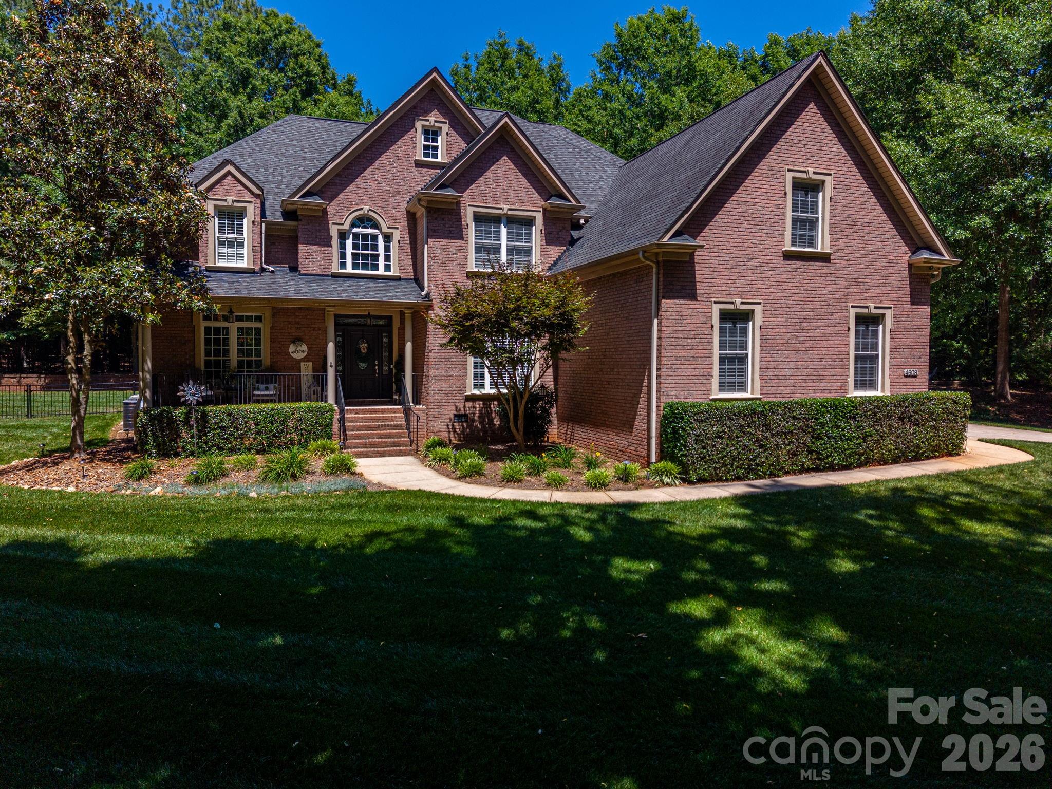 Beautifully appointed full-brick home located in charming lake community in Lake Wylie.  This spacious residence features welcoming front porch with lake view.  Impressive foyer showcases elegant oak staircase accented by wrought-iron spindles.  Private office with full bath, formal dining room with lovely architectural details.  Stunning kitchen with granite counter tops and glass tile and subway tile backsplash.  Gourmet kitchen includes breakfast nook, island, stainless steel appliances (including gas stove), rich dark wood cabinetry, and walk-in pantry. Tasteful powder room conveniently located for guests.  The kitchen opens to a spacious family room accented by lovely fireplace.  Upstairs, the luxurious primary suite features a decorative trey ceiling, sitting area, cozy fireplace,  and built-ins.  Spa-like bath has dual vanities, garden tub and separate shower.  Additional flexible spaces include a bonus room with private bath and a theater room.  Plantation shutters throughout. Enjoy outdoor entertaining with a new Trex deck, patio, wrought-iron fenced backyard and firepit area.  Spacious side-load garage with ample parking completes this exceptional home.