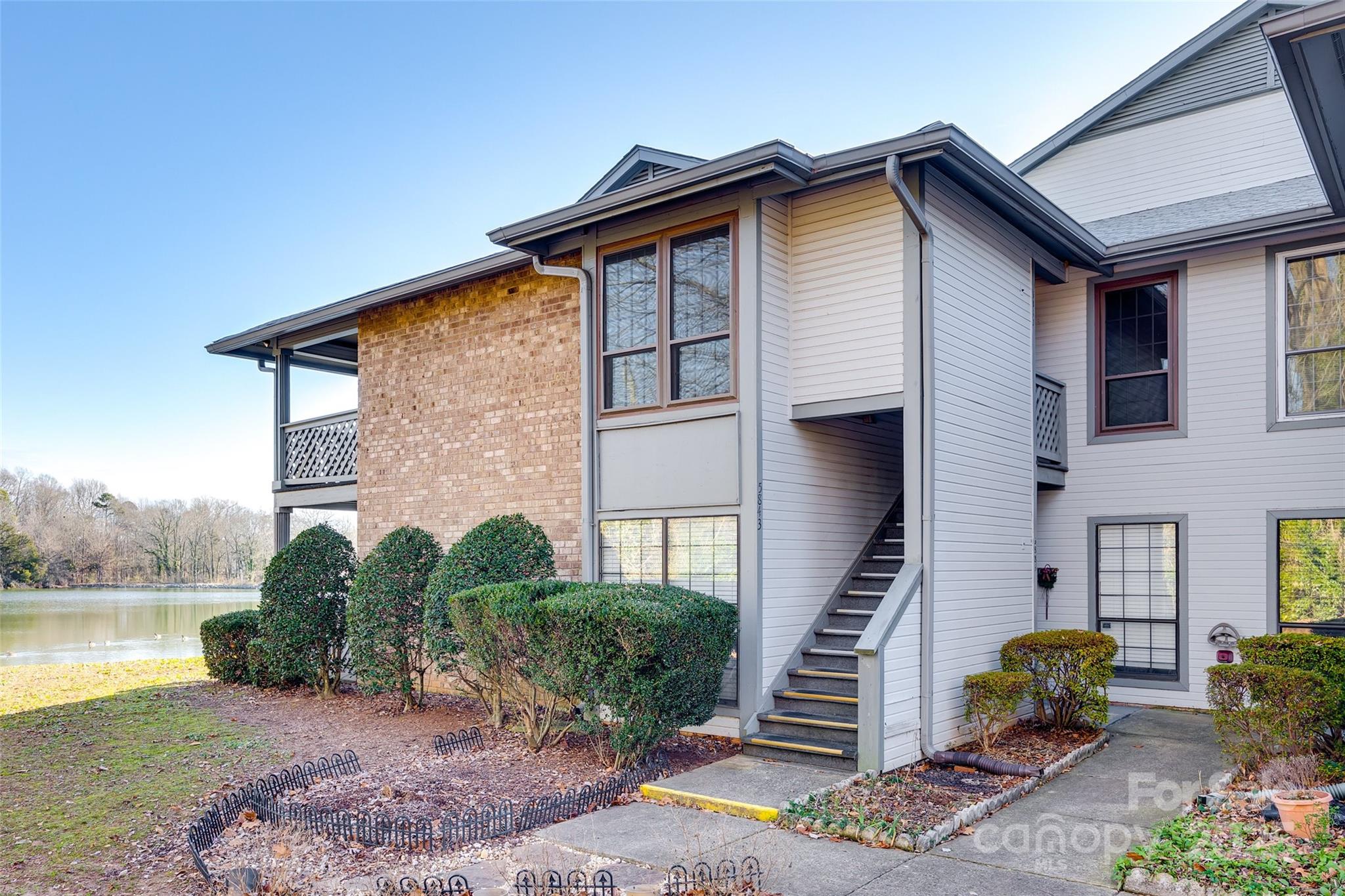 End unit condo that overlooks a peaceful pond and is also close to the community pool & clubhouse! Spacious layout with brick fireplace and kitchen with plenty of cabinets/counter space. Tons of light in the living & dining rooms with large windows. Primary suite has 2 closets and garden tub and 2nd bathroom has updated bath fitter walk-in shower. Enjoy the roomy covered back porch with extra storage. Building has new roof and HVAC replaced in 2023! Convenient to Uptown, airport & NoDa. Refrigerator, washer & dryer remain so all you have to do is unpack and relax. Come discover it today!