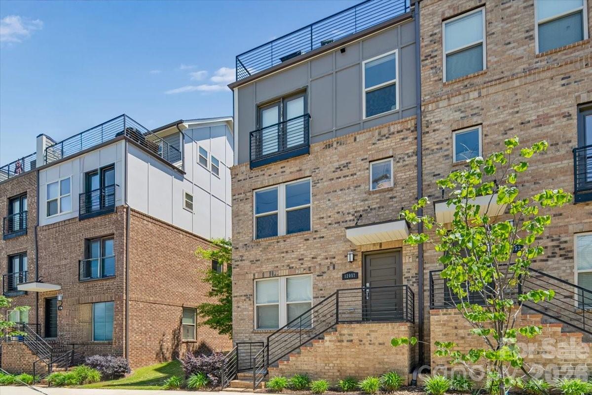 Welcome to elevated urban living in the heart of Charlotte. Located in the highly sought-after Central Point community, this exceptional four-story end-unit townhome at 12057 Brooklyn Ave offers the perfect blend of luxury, functionality, and an unbeatable location—just steps from the Little Sugar Creek Greenway and minutes to Uptown Charlotte, Plaza Midwood, and NoDa.

Thoughtfully designed to mirror the model home, this one-owner residence showcases top-of-the-line upgrades throughout while still feeling like new construction. As an end unit, it features additional windows that flood the home with natural light, enhanced by automatic shades for both convenience and style, and beautifully highlighting the hardwood floors that run throughout the main living spaces.

The main level is designed for both everyday living and effortless entertaining. A stunning chef’s kitchen anchors the space, complete with high-end coordinating appliances, an oversized island with breakfast bar, abundant cabinetry, generous counter space, and a pantry. The kitchen flows seamlessly into the dining area and spacious living room, while a private balcony just off the kitchen provides the perfect spot for grilling, relaxing, or enjoying fresh air.

Upstairs, the spacious owner’s suite offers a true retreat, complemented by a spa-like bath and ample closet space. Two additional bedrooms each feature their own en-suite bathrooms and walk-in closets, providing privacy and flexibility for guests, roommates, or a home office setup.

One of the home’s most impressive features is the private rooftop terrace—an ideal setting for relaxing or entertaining with sweeping views of the Charlotte skyline. Whether you're enjoying a quiet morning coffee or unwinding by a fire pit at sunset, this space delivers a rare and elevated outdoor experience.

Additional highlights include a tandem two-car garage. Outdoor enthusiasts will love the immediate access to miles of greenway trails, while city lovers will appreciate quick access to I-277 and close proximity to Charlotte’s best dining, breweries, shopping, and entertainment.

This is a rare opportunity to own a low-maintenance, luxury townhome in one of Charlotte’s most vibrant and connected neighborhoods—perfect for both homeowners and investors alike.