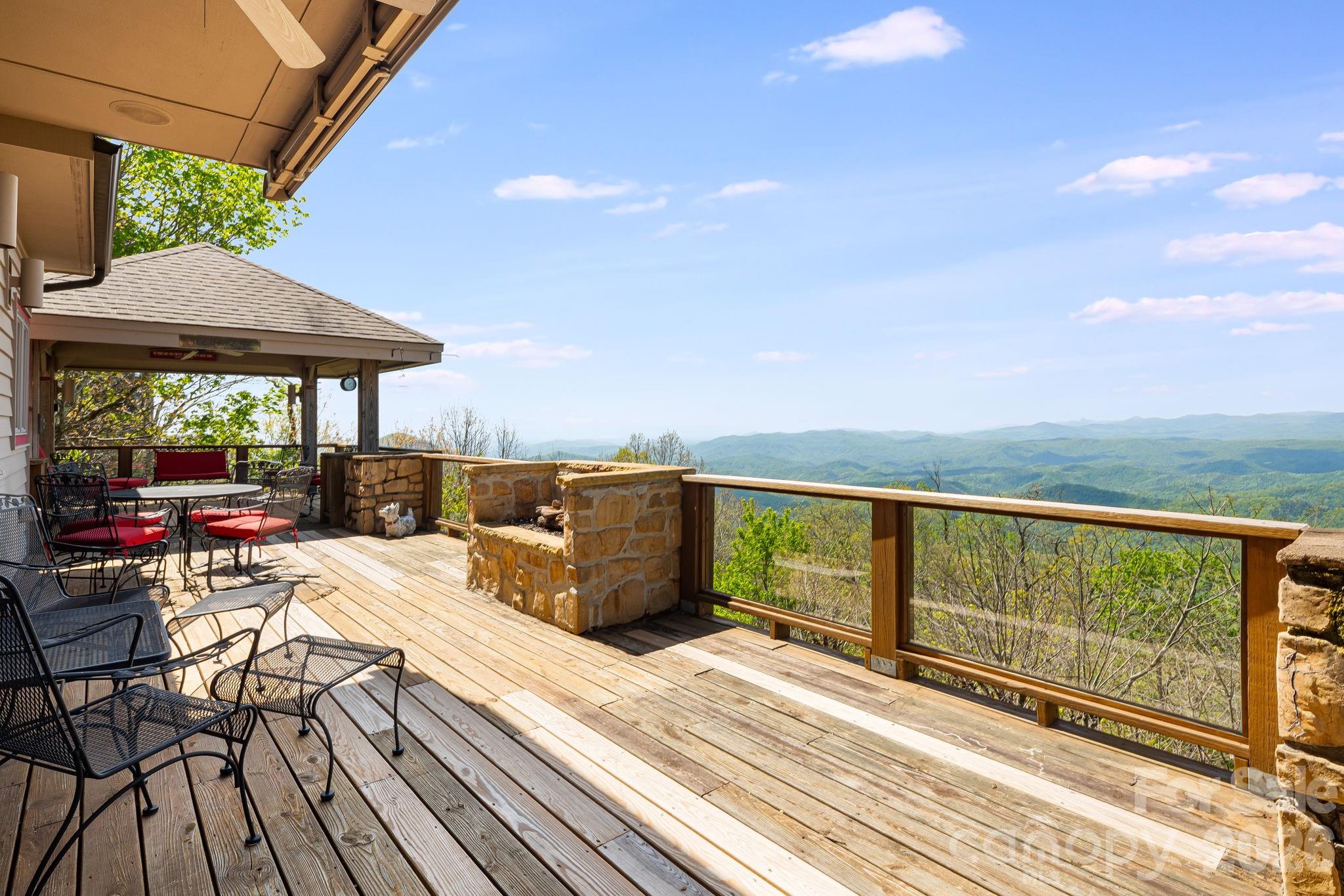 Welcome to 206 Twin Springs Road—your private mountain retreat with sweeping, panoramic views of the Johns River Gorge and the Blue Ridge Mountains. This exceptional property offers a rare blend of comfort, character, and location, creating an ideal year-round escape or full-time residence. Thoughtfully designed for both relaxation and entertaining, the home features inviting interior spaces complemented by expansive outdoor decks and a beautifully crafted, tiered stone garden. Offered for the first time since 1970, this is a truly special opportunity in one of Blowing Rock’s most desirable settings.
Location is everything: enjoy breathtaking long-range views, stroll to the charming shops, restaurants, and park in downtown Blowing Rock, or take a short golf cart ride to Blowing Rock Country Club. Boone and several of North Carolina’s premier ski resorts are just minutes away, with Charlotte and Greensboro approximately two hours’ drive. The main level offers easy access from the four-car driveway and is perfectly suited for single-level living. Highlights include a bedroom and full bath, a well-appointed kitchen with double ovens, dining area, and a spacious family room anchored by a wall of windows framing the spectacular views. A cozy library or office provides a quiet retreat, while direct access to the expansive back deck, complete with a fireplace and a covered
section fondly known as the “Treehouse,” invites year-round outdoor enjoyment. Upstairs, the primary suite is a peaceful sanctuary featuring its own private balcony with stunning views, a full bath, generous storage, and a dedicated sitting or reading area. The lower level includes two additional bedrooms, each with en suite baths (featuring 6’10” ceilings and included in the additional 558 square feet of living space), along with
a large laundry room with a convenient chute from the upper floors and a spacious utility room.
Offered fully furnished, including all existing furniture as well as the washer and dryer, this home is ready to be enjoyed from day one.