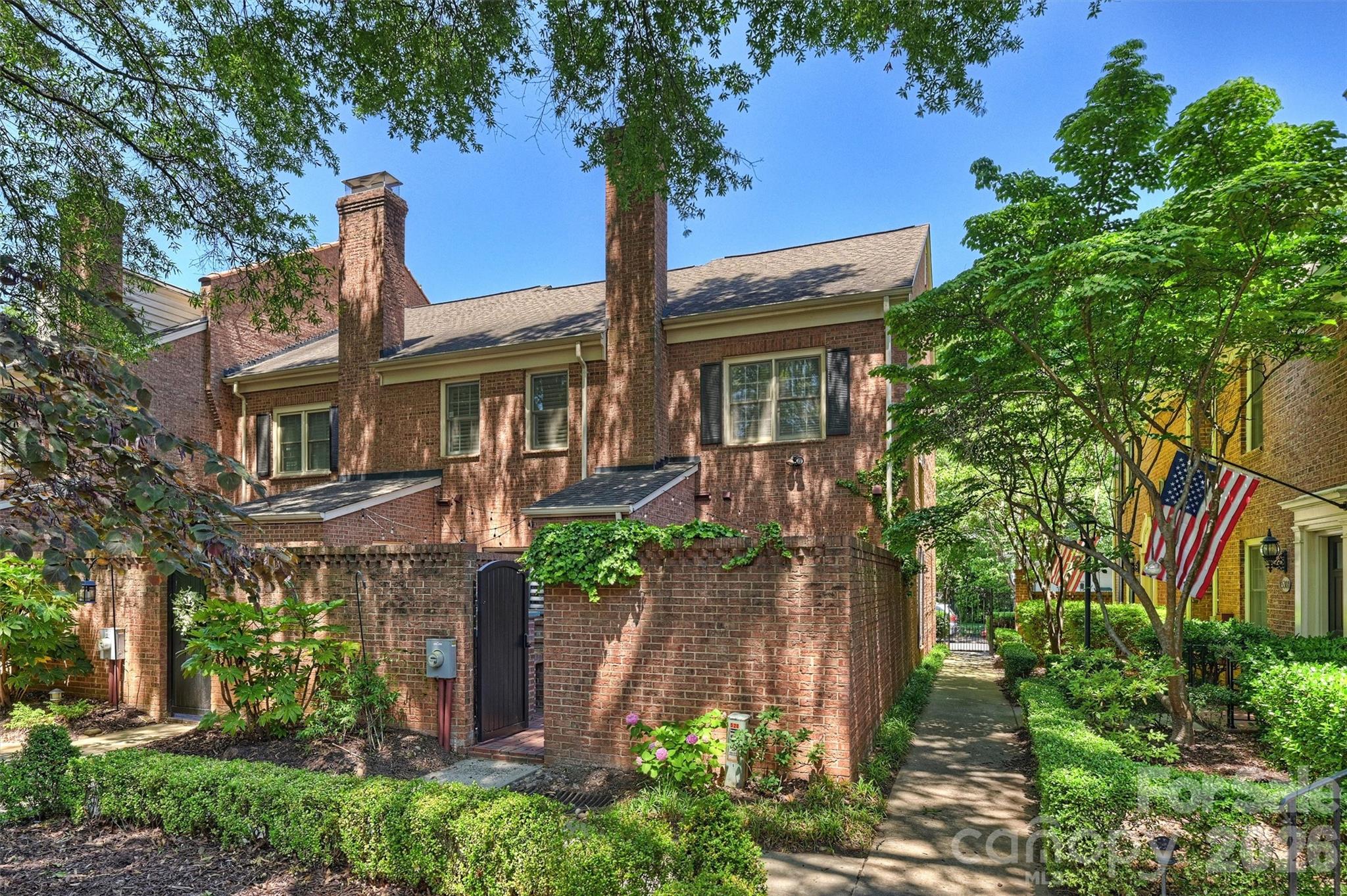 Most people think Uptown living means high-rises, parking decks, and busy streets. Tucked beneath a canopy of mature trees in Fourth Ward, Hackberry Court offers something entirely different: a quiet courtyard community where brick walkways, skyline views, and a true neighborhood atmosphere create one of Charlotte’s most unique urban living experiences.

Hidden inside one of Fourth Ward’s most charming brick courtyards, this two-story end-unit combines walkability and convenience with a level of privacy and character that’s increasingly difficult to find. Leave the car in your dedicated gated parking space and walk to work, Panthers games, Hornets games, Fourth Ward Park, Harris Teeter, Tryon Street, and Alexander Michael’s.

Inside, natural light pours through additional corner windows unique to the end-unit location. Dark hardwood floors, updated lighting, and a flexible front room create a layout that adapts easily to dining, entertaining, or working from home. The living room centers around a limewashed brick wood-burning fireplace, custom built-ins, and French doors opening directly to the courtyard.

Upstairs, you’ll find two bedrooms and two full baths, including a vaulted primary suite with dual closets. A main-level powder room, gated parking, and move-in-ready condition make everyday living easy.

For buyers looking for Uptown convenience without high-rise living, 520 N Poplar Unit I offers something increasingly rare: walkability, privacy, outdoor space, and a genuine neighborhood feel in the heart of the city.