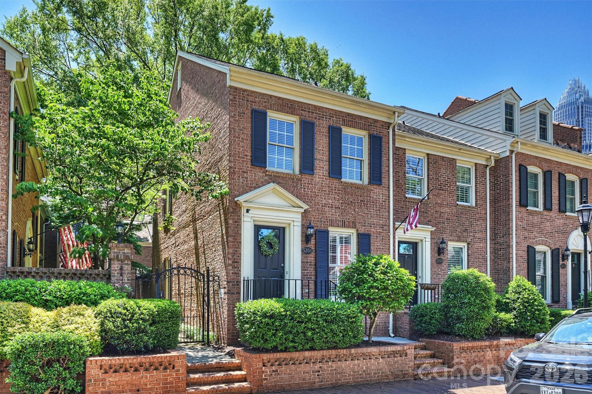 Hidden inside one of Fourth Ward’s most charming brick courtyards, this unique 2-story end-unit offers a version of Uptown living that’s increasingly hard to find.

Hackberry Court feels tucked away from the city while still sitting right in the middle of it. Mature trees, brick walkways, skyline peeks through the canopy, and a quiet courtyard atmosphere create a true neighborhood feel just blocks from Uptown’s restaurants, sports, and nightlife.

Leave the car parked in your dedicated gated parking space and walk to Panthers games, Hornets games, Fourth Ward Park, Tryon Street, Harris Teeter, and longtime local favorite Alexander Michael’s.

Inside, the home balances warmth and functionality with strong natural light from end-unit windows, dark hardwood floors, updated lighting, and a flexible front room that works equally well as a dining space or home office. The living room centers around a limewashed brick wood-burning fireplace, white built-ins, and French doors opening to the private brick courtyard.

Upstairs, you’ll find two bedrooms and two full baths, including a vaulted primary suite with dual closets. A main-level powder room, gated parking, and move-in-ready presentation make everyday living easy.

For buyers looking for Uptown convenience without high-rise living, 520 N Poplar offers something rarer: privacy, character, outdoor space, and one of the most walkable neighborhood settings in Charlotte.

Showings begin Friday, May 29.