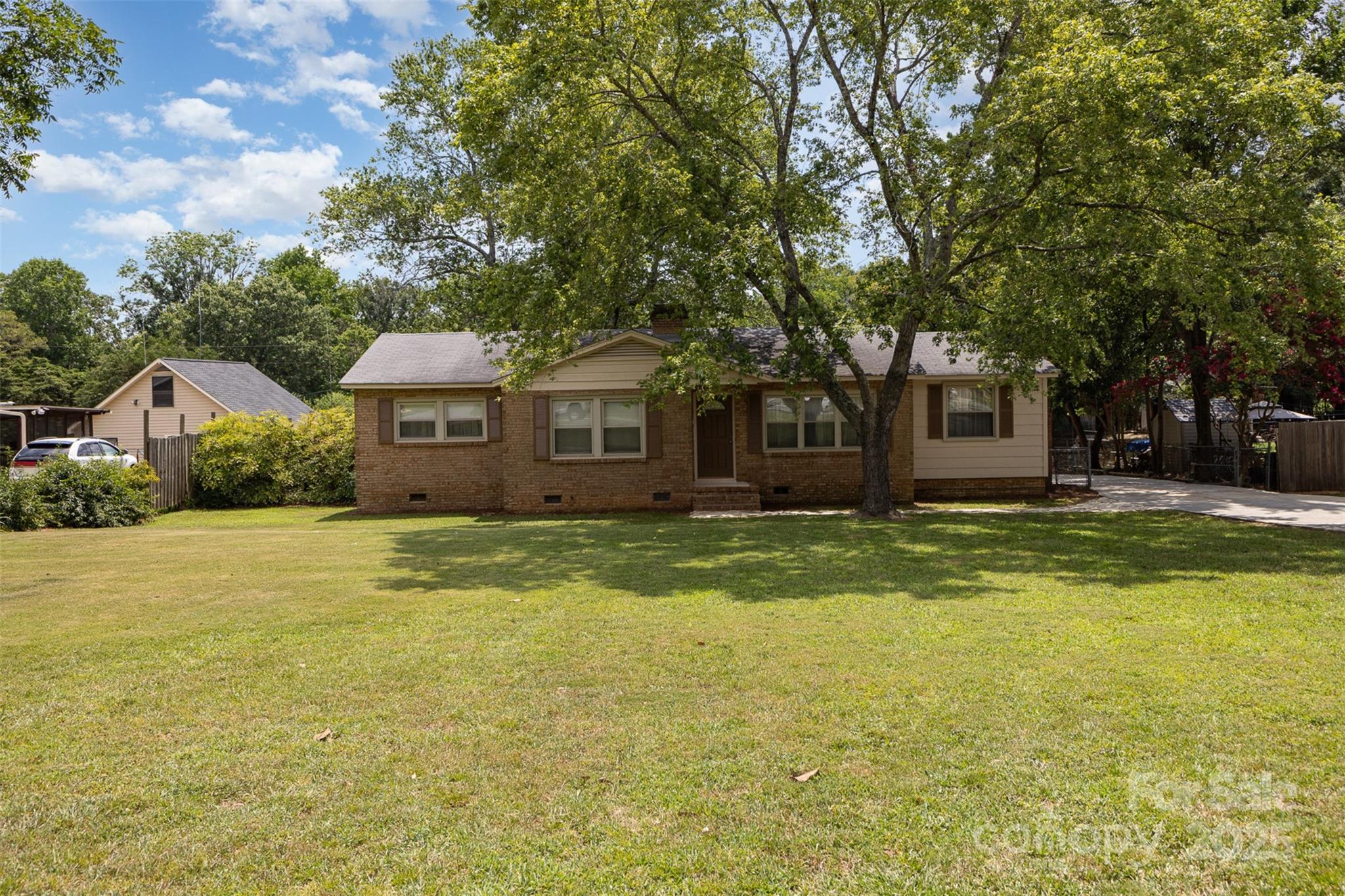 Priced to sell and Move In Ready!  Charming and well-maintained brick ranch.  This fully fenced property features a private backyard, oversized driveway with ample parking, a detached 32x24 workshop/garage with 220 amp power—ideal for storage, hobbies, or a home-based business and a wood shed is located behind the garage. Enjoy the step-down family room complete with a cozy gas fireplace and spacious living room — ideal for quiet nights or gatherings. Recent updates include a brand-new HVAC system/gas furnace, new carpet, fresh interior, exterior paint  — plus new plumbing fixtures in both the kitchen and bathroom. The kitchen has all-new appliances—oven, cooktop, microwave, dishwasher, and French door refrigerator and features custom hand built, solid wood cabinets. Close to I-77, shopping and restaurants.
