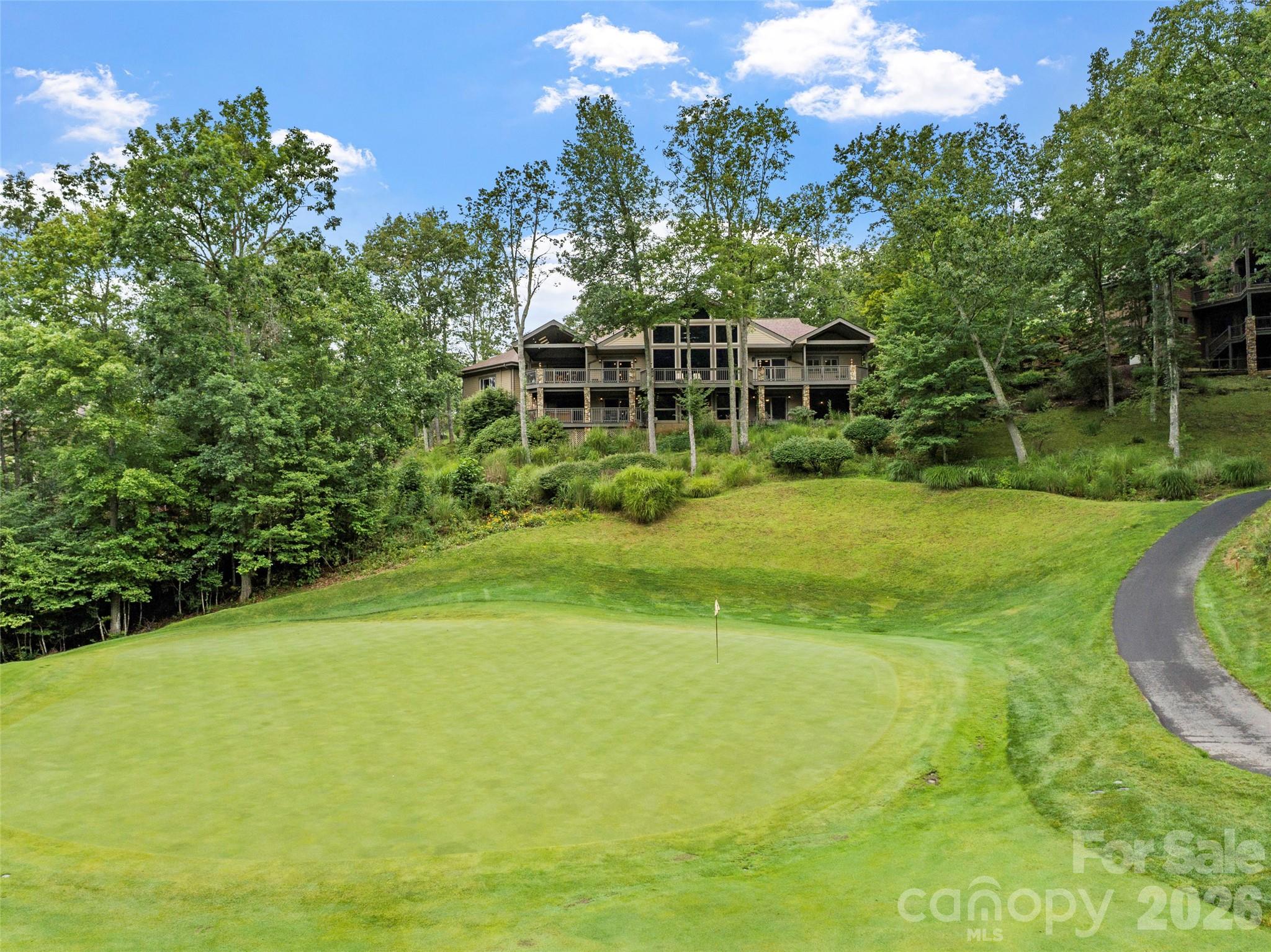 Perched above the 11th fairway in the prestigious Mountain Air Country Club, this exceptional estate offers a rare opportunity to experience refined mountain living with breathtaking long-range views, elevated design, and an unmatched lifestyle.

From the moment you arrive, the setting makes a lasting impression. Sweeping vistas of the golf course and Blue Ridge Mountains create a sense of privacy and tranquility, while the home itself reflects a seamless blend of timeless craftsmanship and modern sophistication.

A comprehensive 2017 renovation thoughtfully reimagined the interior, introducing wide-plank flooring, designer lighting, and a beautifully appointed gourmet kitchen featuring premium BOSCH appliances, perfect for both everyday living and elegant entertaining. Recent updates include a new roof (2020), expansive Trex decking, and a newly paved asphalt driveway (2024), enhancing both function and curb appeal.

The home offers four spacious en-suite bedrooms, providing comfort and privacy for family and guests. A dedicated wellness retreat includes a private fitness space, steam shower, and infrared sauna, creating a spa-like experience within your own home. Just beyond, a six-person Hot Springs spa invites you to relax and take in the surrounding mountain views. An impressive executive office suite with custom built-ins and granite countertops provides a refined and inspiring work-from-home environment.

Included in the purchase is a $100,000 Full Golf Membership, granting access to the premier amenities of Mountain Air, an exclusive gated mountaintop community known for its private runway, championship golf course, clubhouse dining, fitness center, tennis courts, parks, and scenic walking trails. At elevations of approximately 3,500 to 4,000 feet, residents enjoy cool summer temperatures and stunning year-round scenery.

Furnishings are negotiable, offering flexibility for a seamless transition or the opportunity to personalize the home to your own vision.

This is more than a home, it is a rare offering of lifestyle, setting, and sophistication in one of Western North Carolina’s most sought-after communities.
